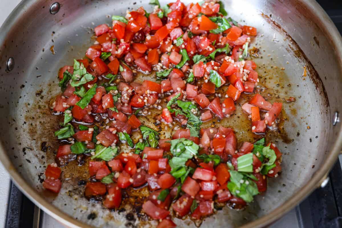 Tomato and basil and garlic cooking in a skillet.