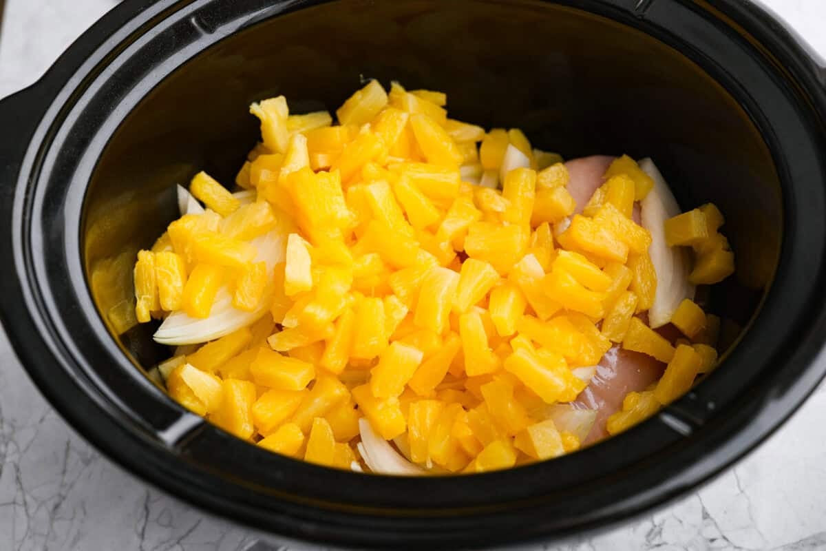 Pineapple and onion added to the crockpot. 