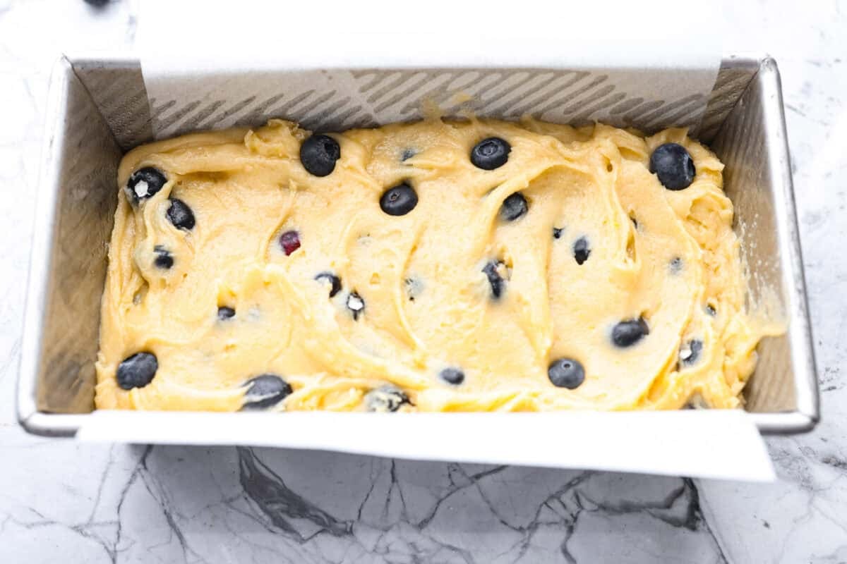 5 ingredient blueberry bread batter added to a loaf pan.