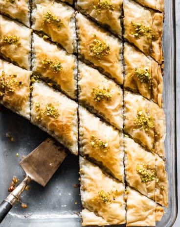 Baklava in a pan with a serving spoon.