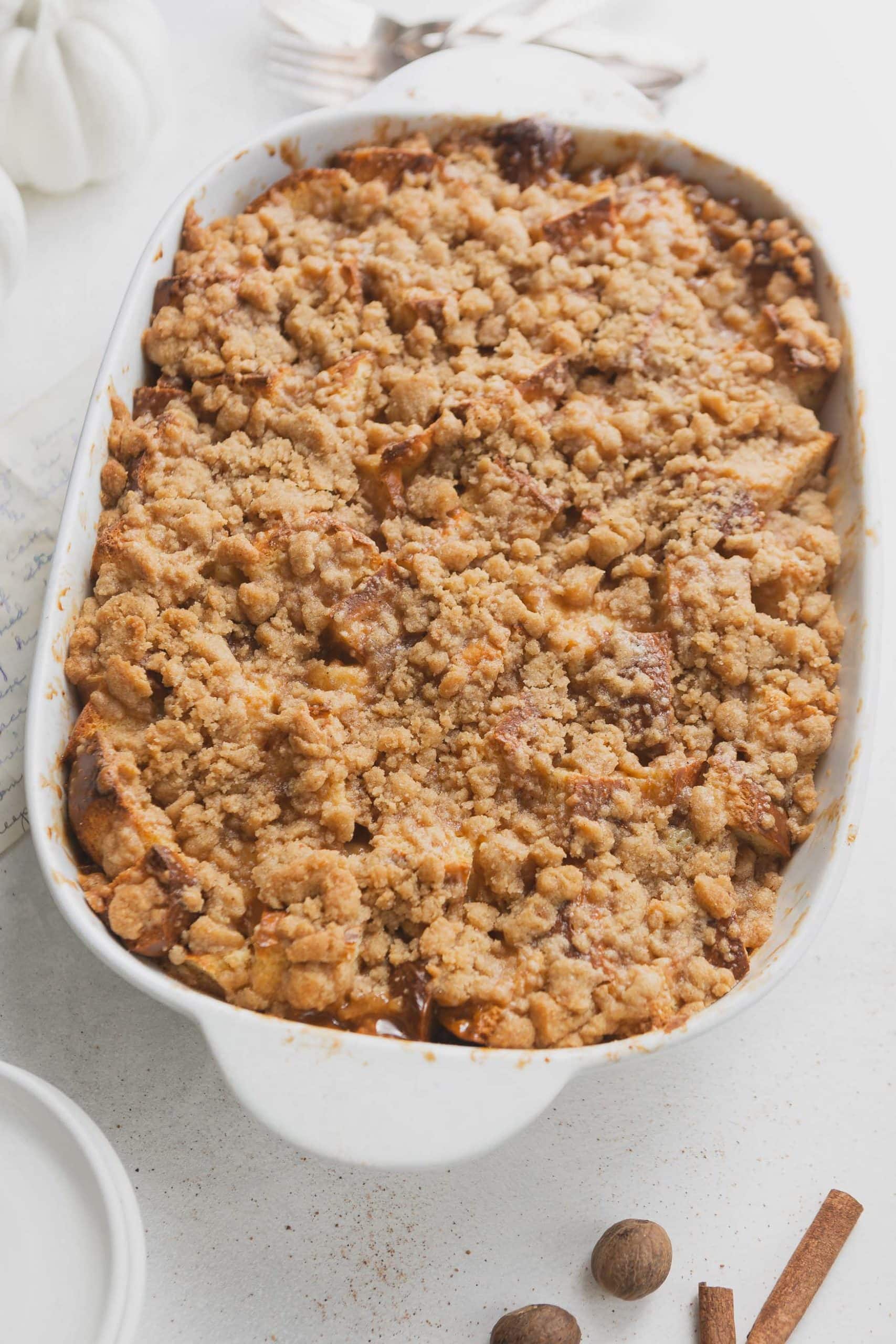 A casserole dish with eggnog french toast. The French toast is topped with a crumb topping.