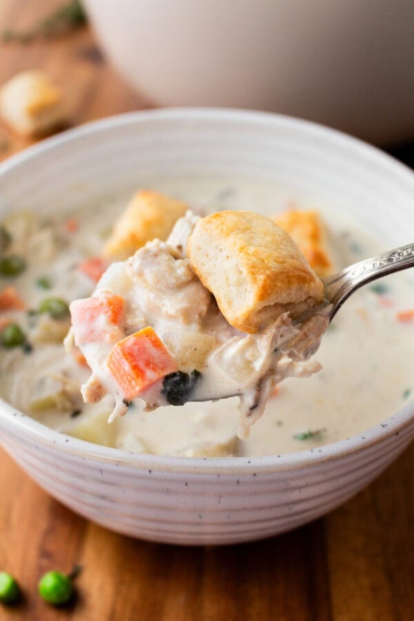 a photo of a bowl of creamy chicken pot pie soup topped with small golden biscuits a photo of a bowl of creamy chicken pot pie soup topped with small golden biscuits