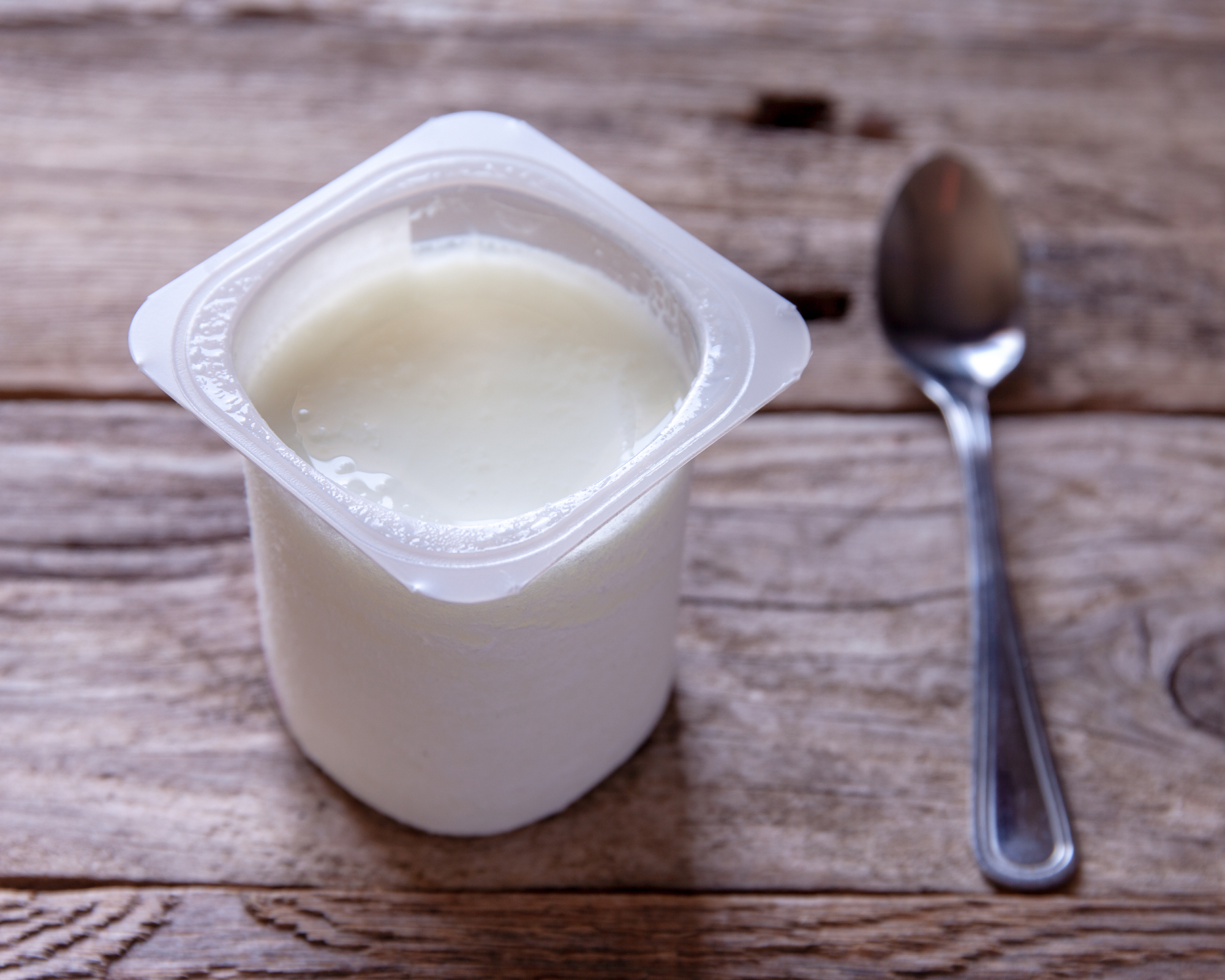 yogurt cup and spoon on tabletop