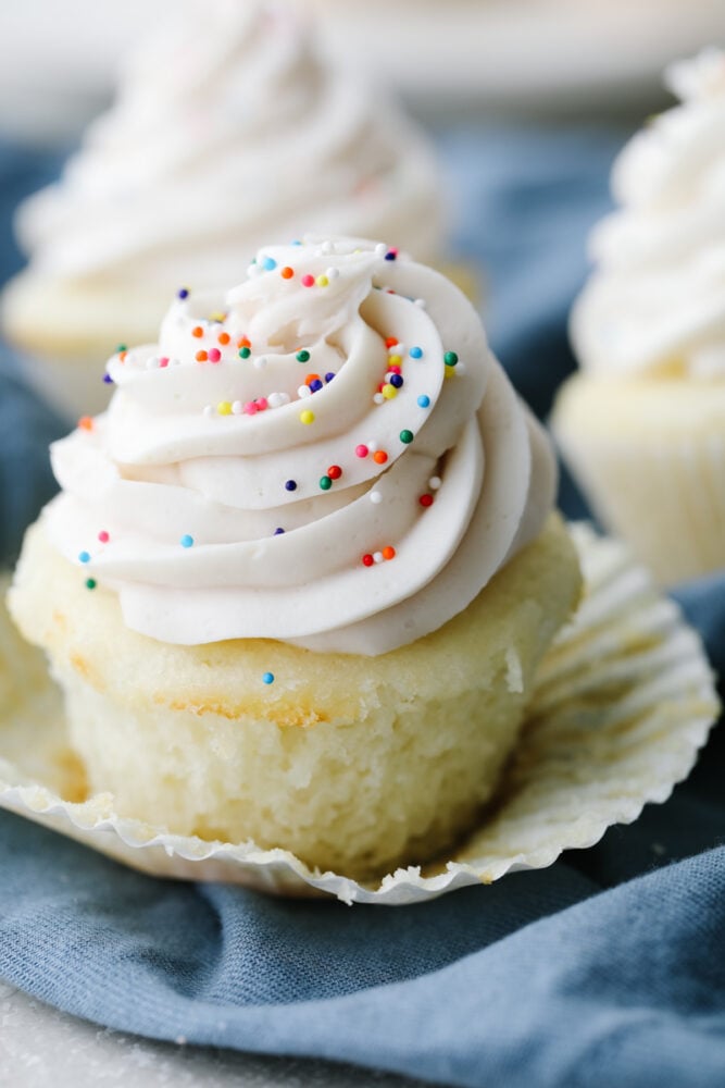 A white cupcake with the liner pulled off. 