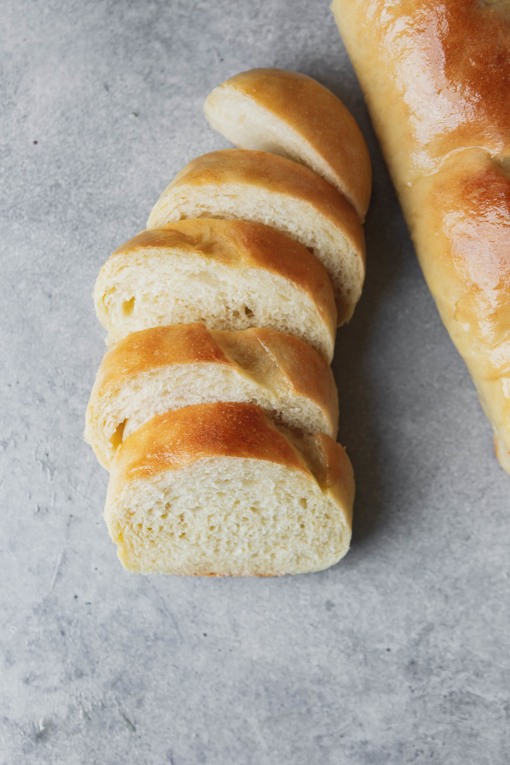 a photo of a loaf of french bread cut into five slices with a full loaf sitting next to the slices. a photo of a loaf of french bread cut into five slices with a full loaf sitting next to the slices.
