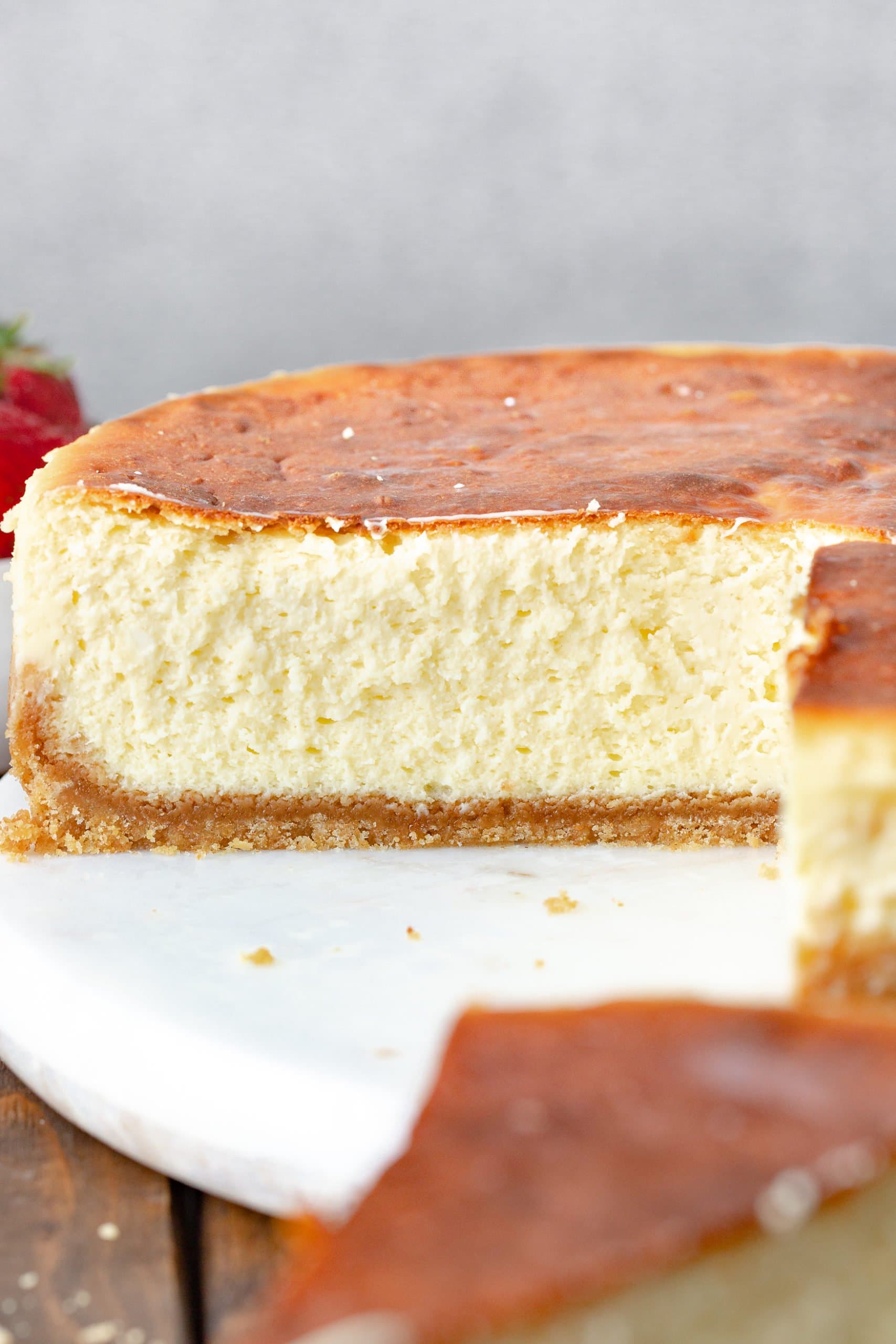 a photo of a whole cheesecake with a golden top 