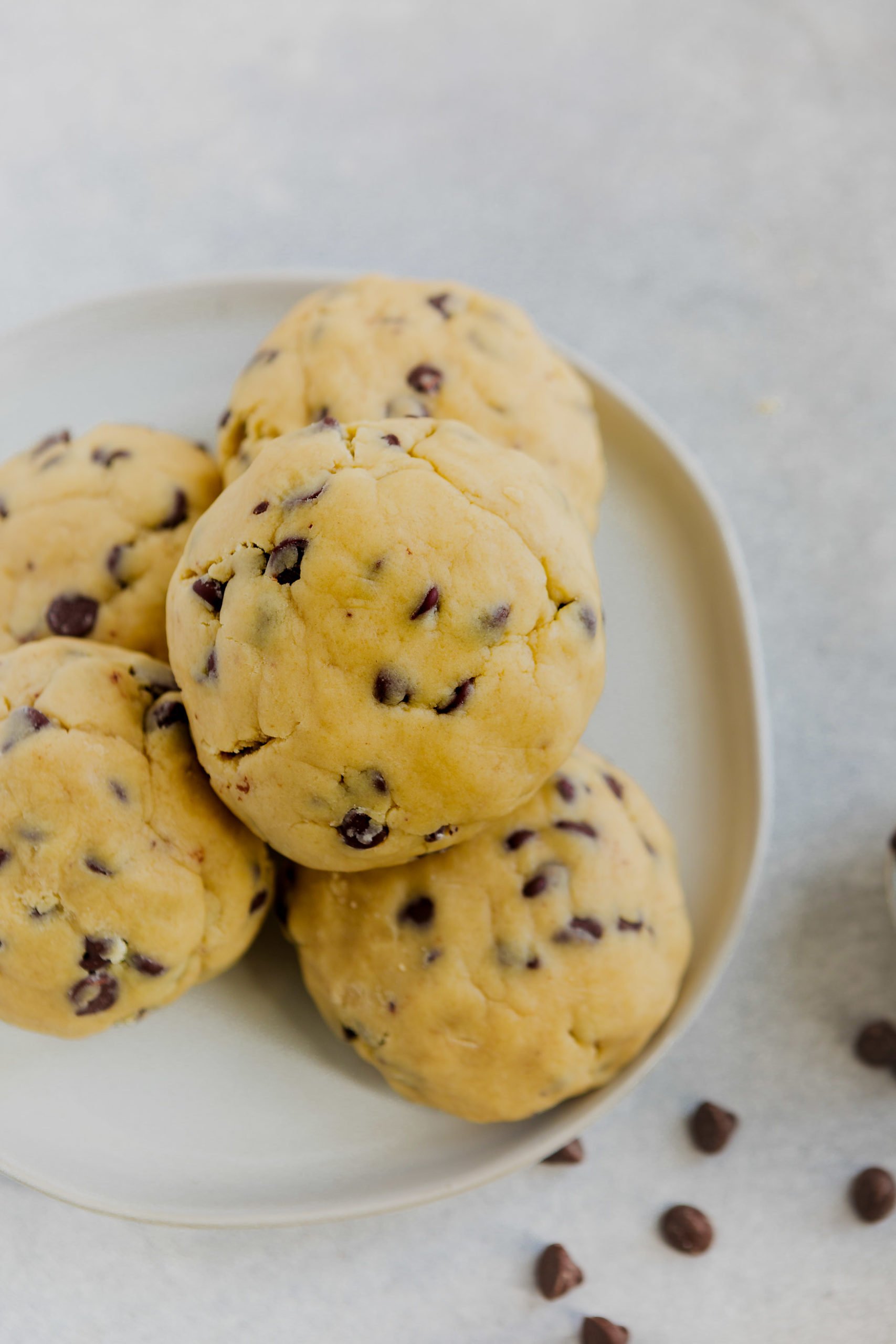 a photo of a plate full of giant thick chocolate chip cookies perfectly baked and golden.