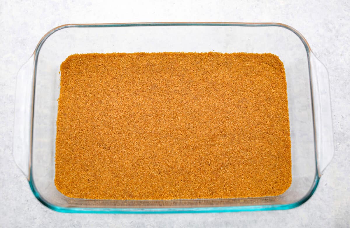 Graham cracker crumb mixture smashed into the bottom of the pan for the crust.