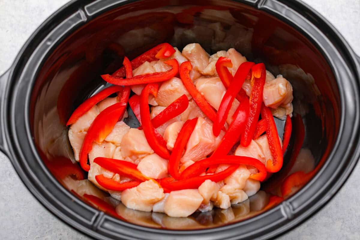 Chicken and peppers added to the slow cooker. 