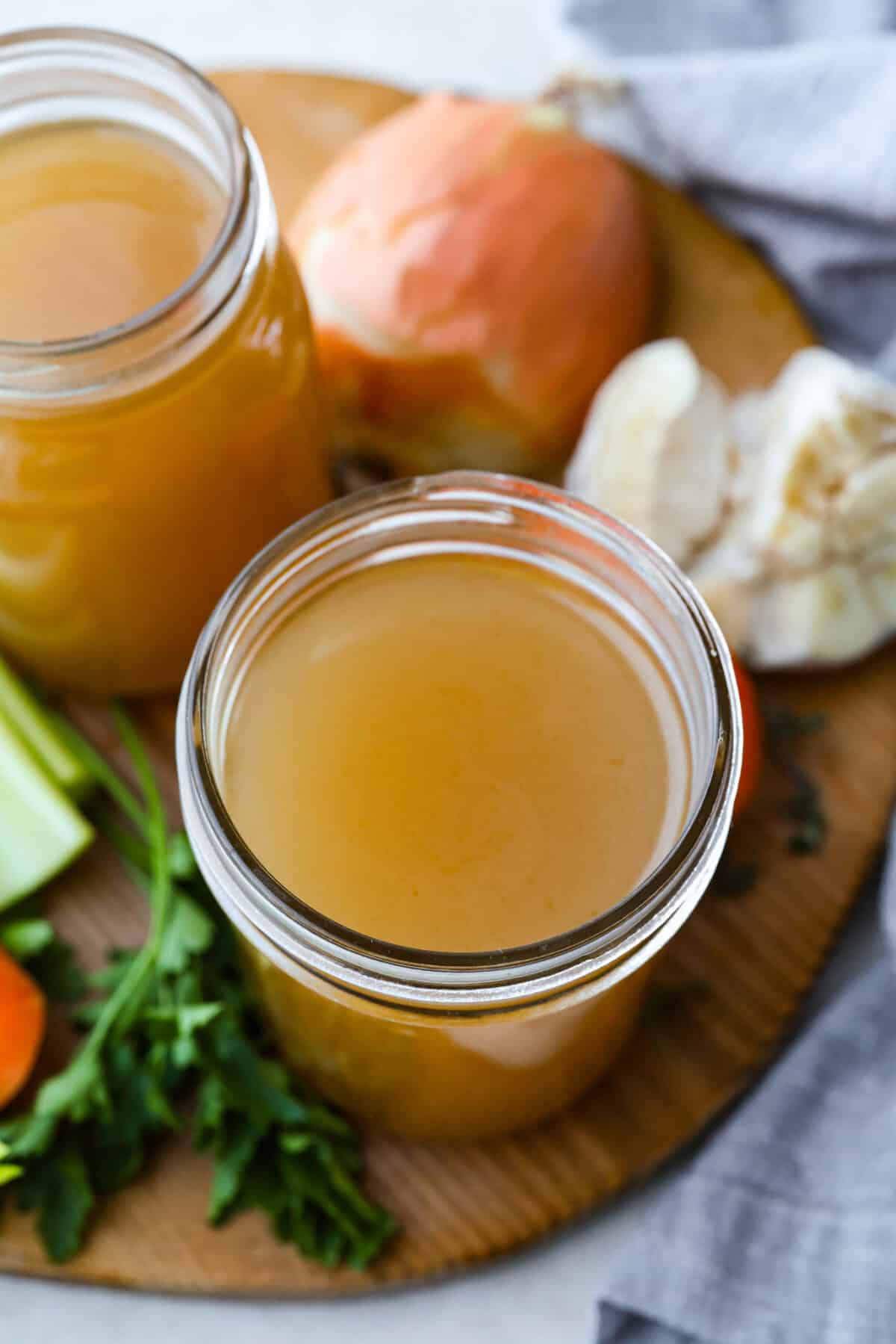 Top down view of the mason jars filled with homemade vegetable broth. 