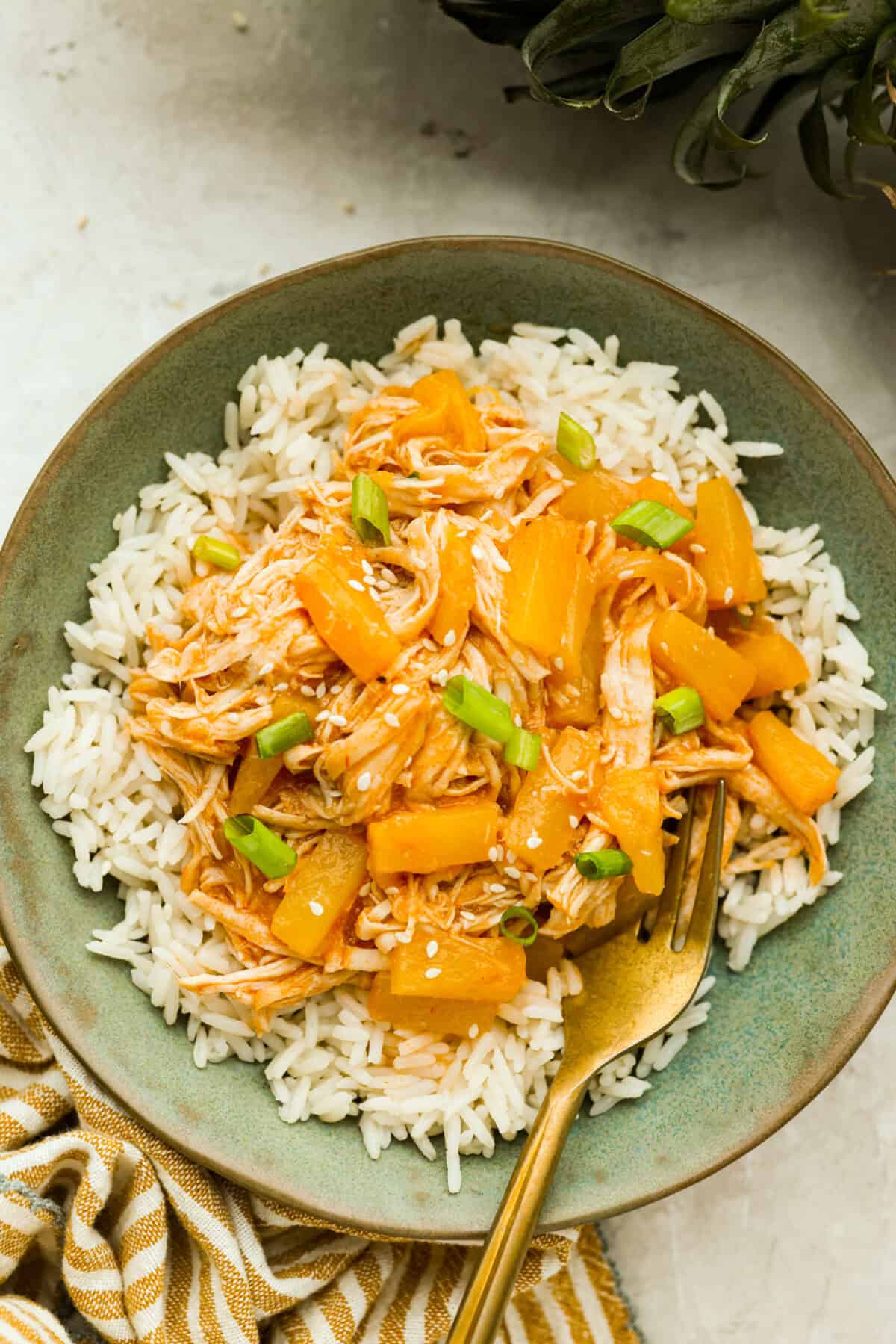 Plated slow cooker aloha chicken on a bed of rice. 