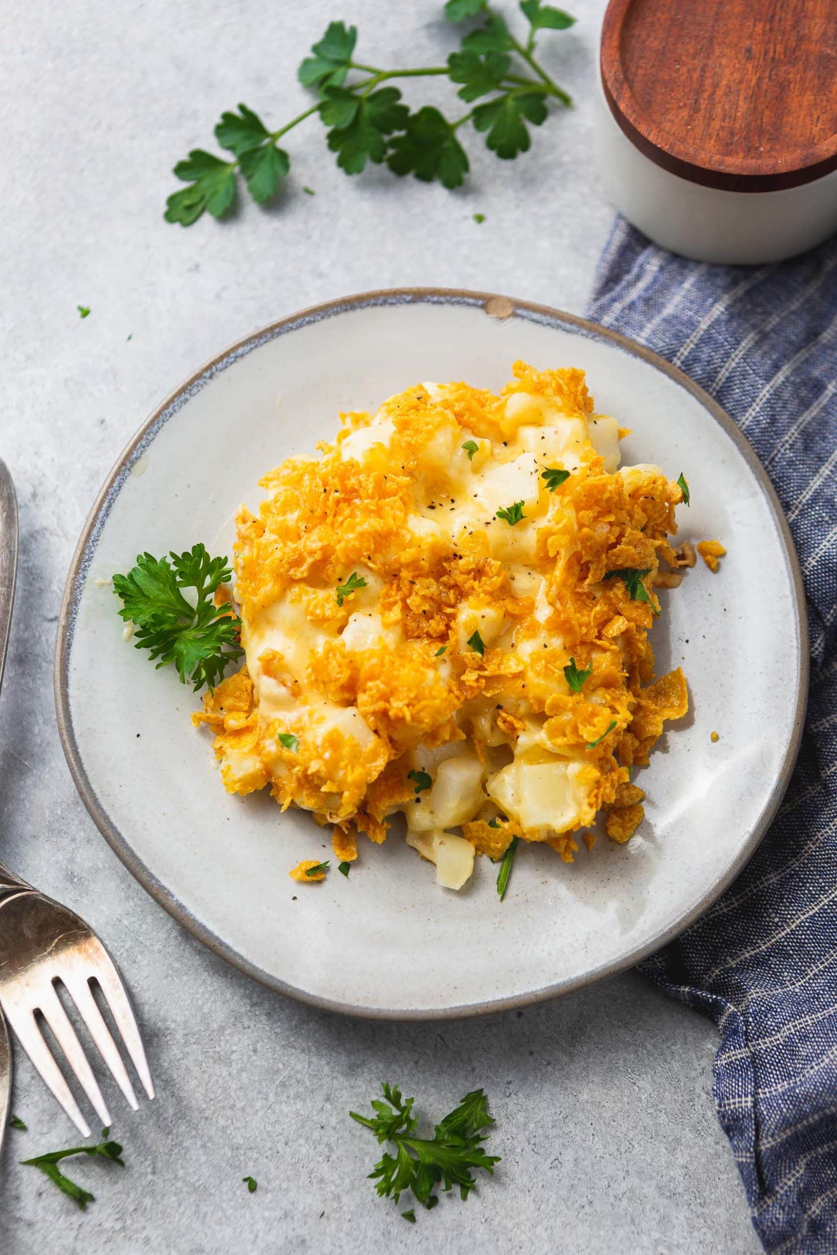 A photo of a plate of cheesy potato casserole topped with golden crunchy topping.
