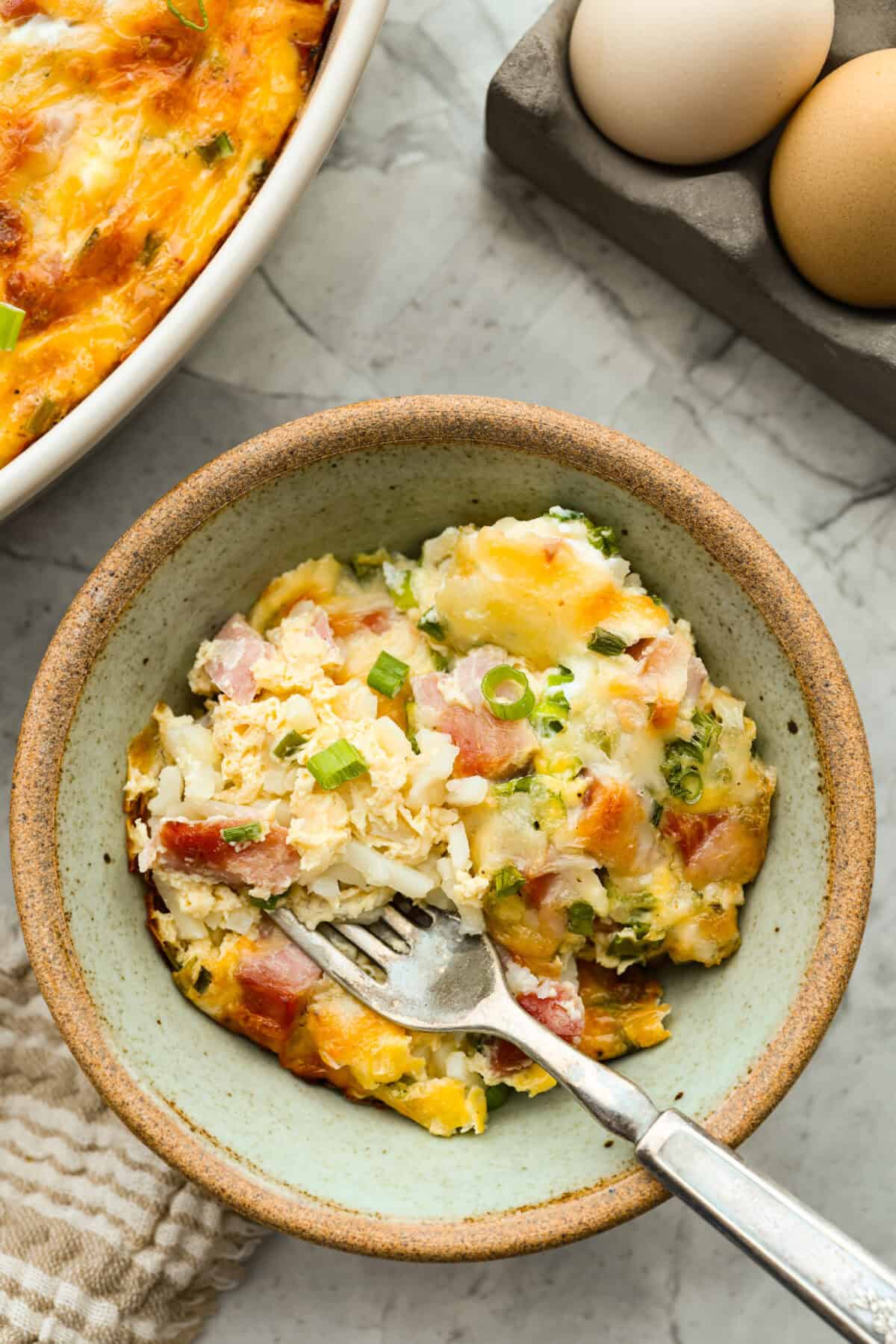 Serving of farmer's casserole in a bowl with a fork. 