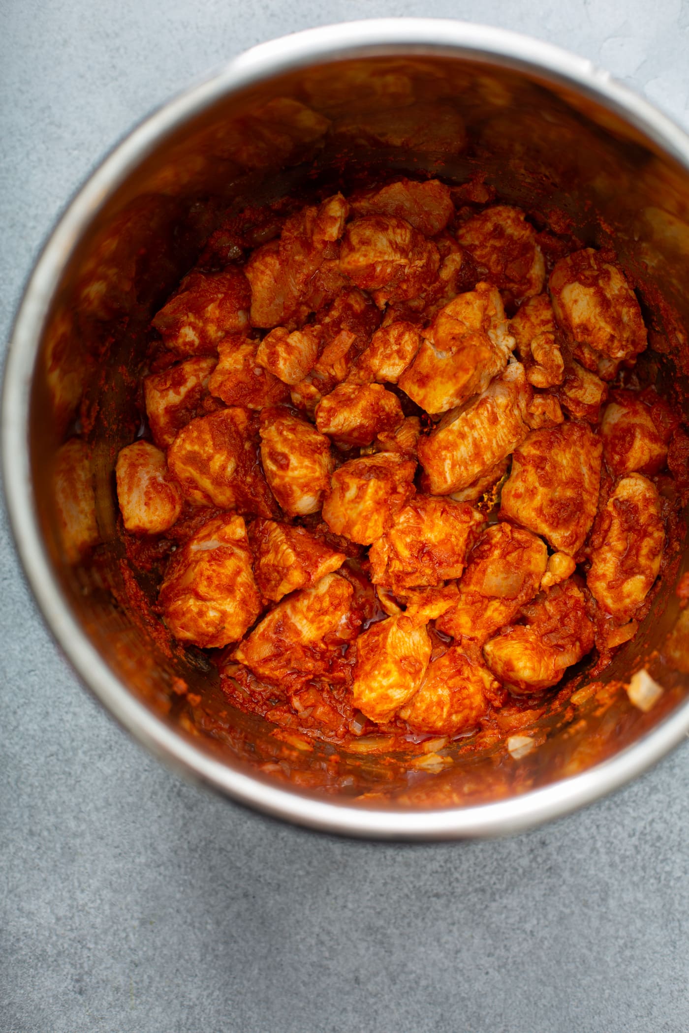 An instant pot with cubed chicken, carrots, and potatoes in a curry sauce.