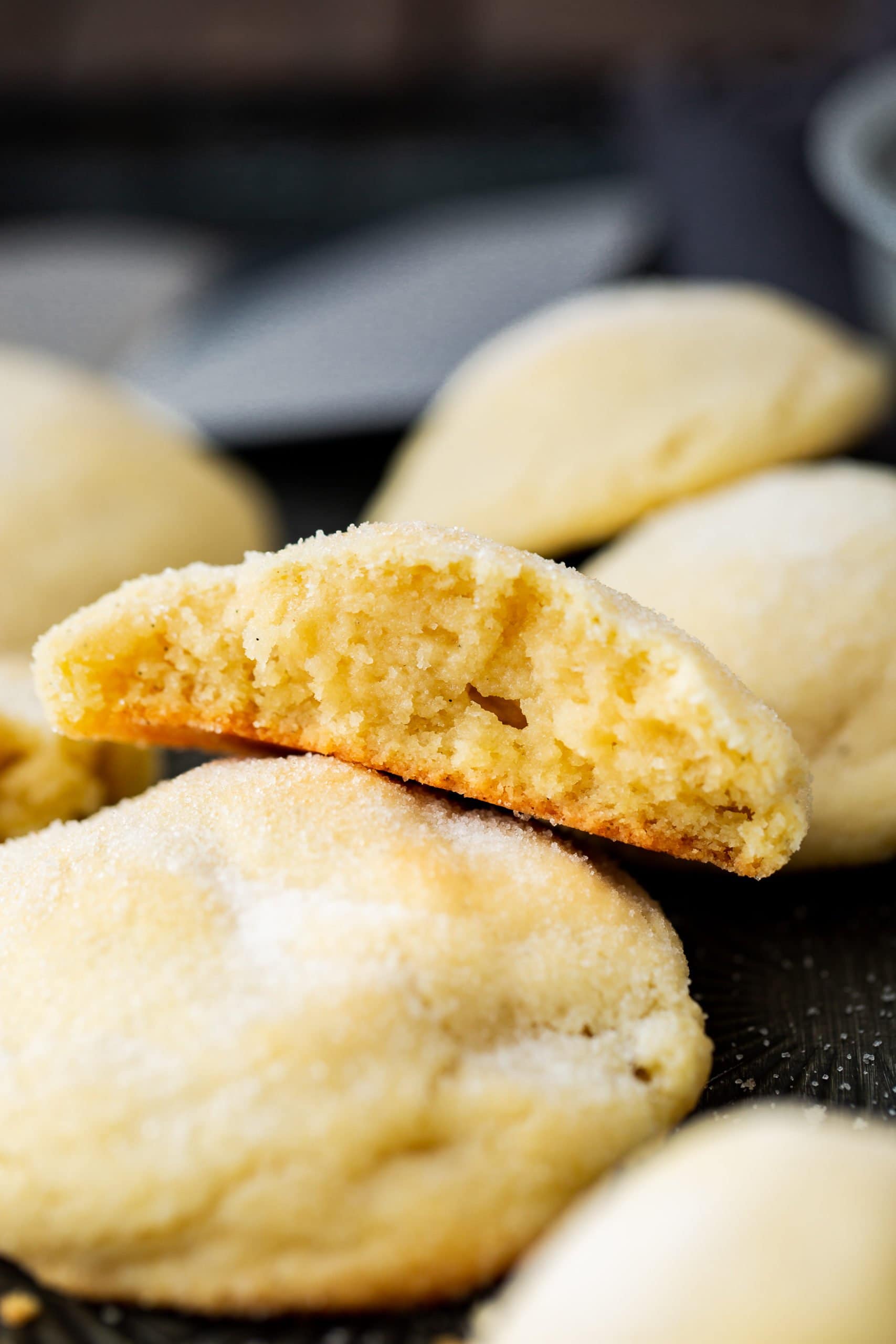 a ohoto of a single cookie that has been broken in half so the inside is facing the camera and it is resting on another whole sugar cookie.