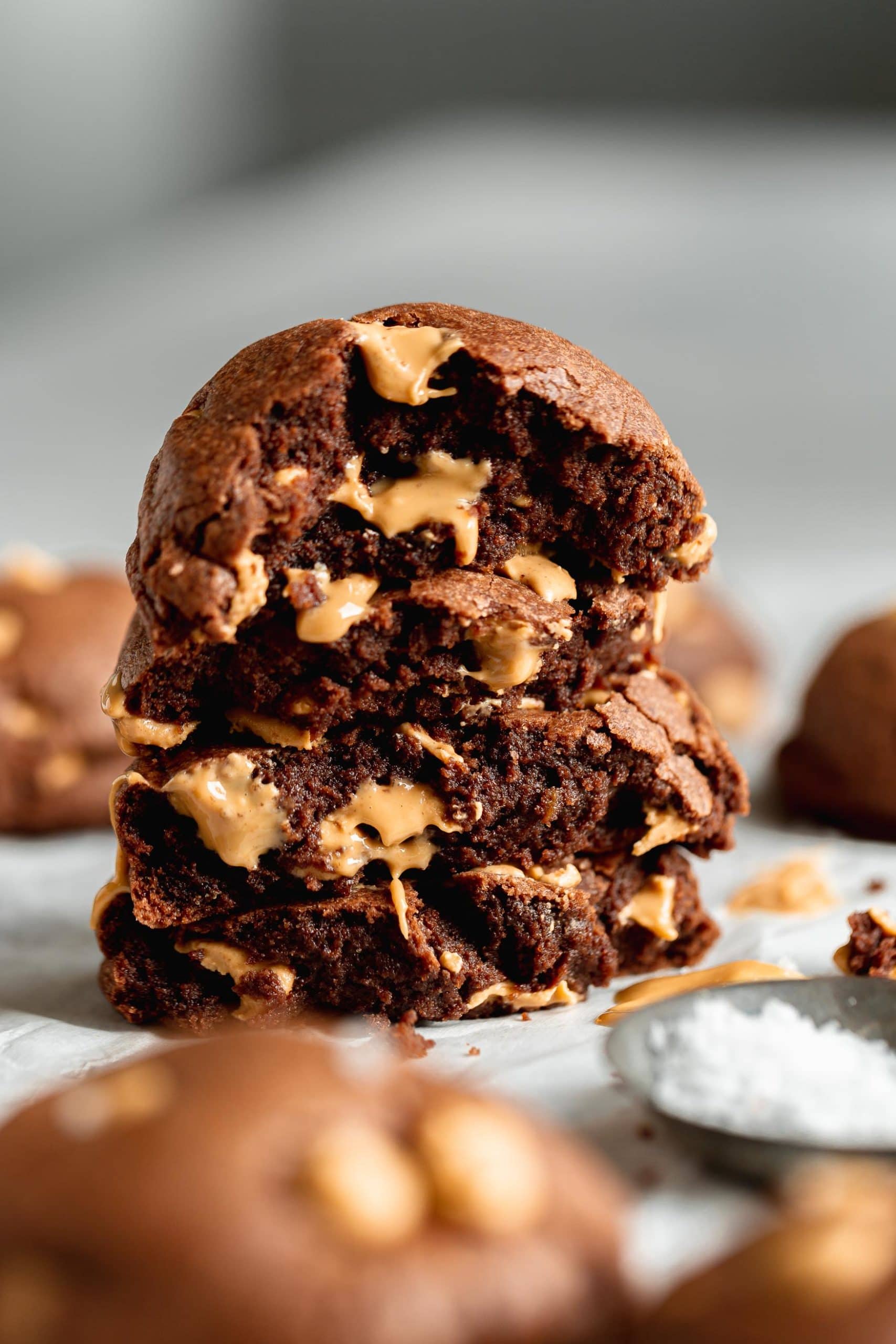 A peanut butter chocolate cookie that is broken in half and stacked on top of each other. You can see the soft chocolate cookie inside with peanut butter chips.