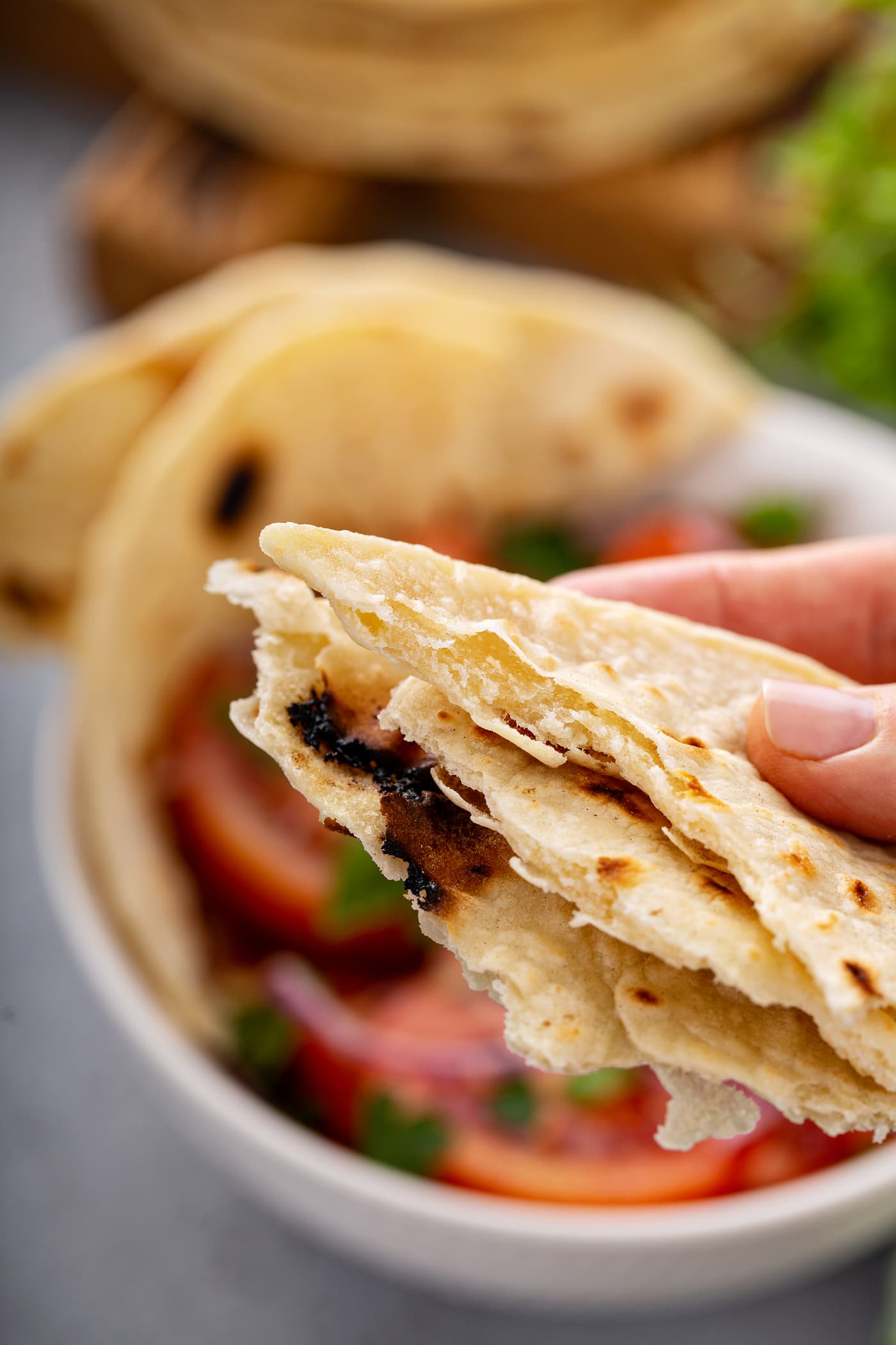 A photo of someone holding portions of torn unleavened bread.