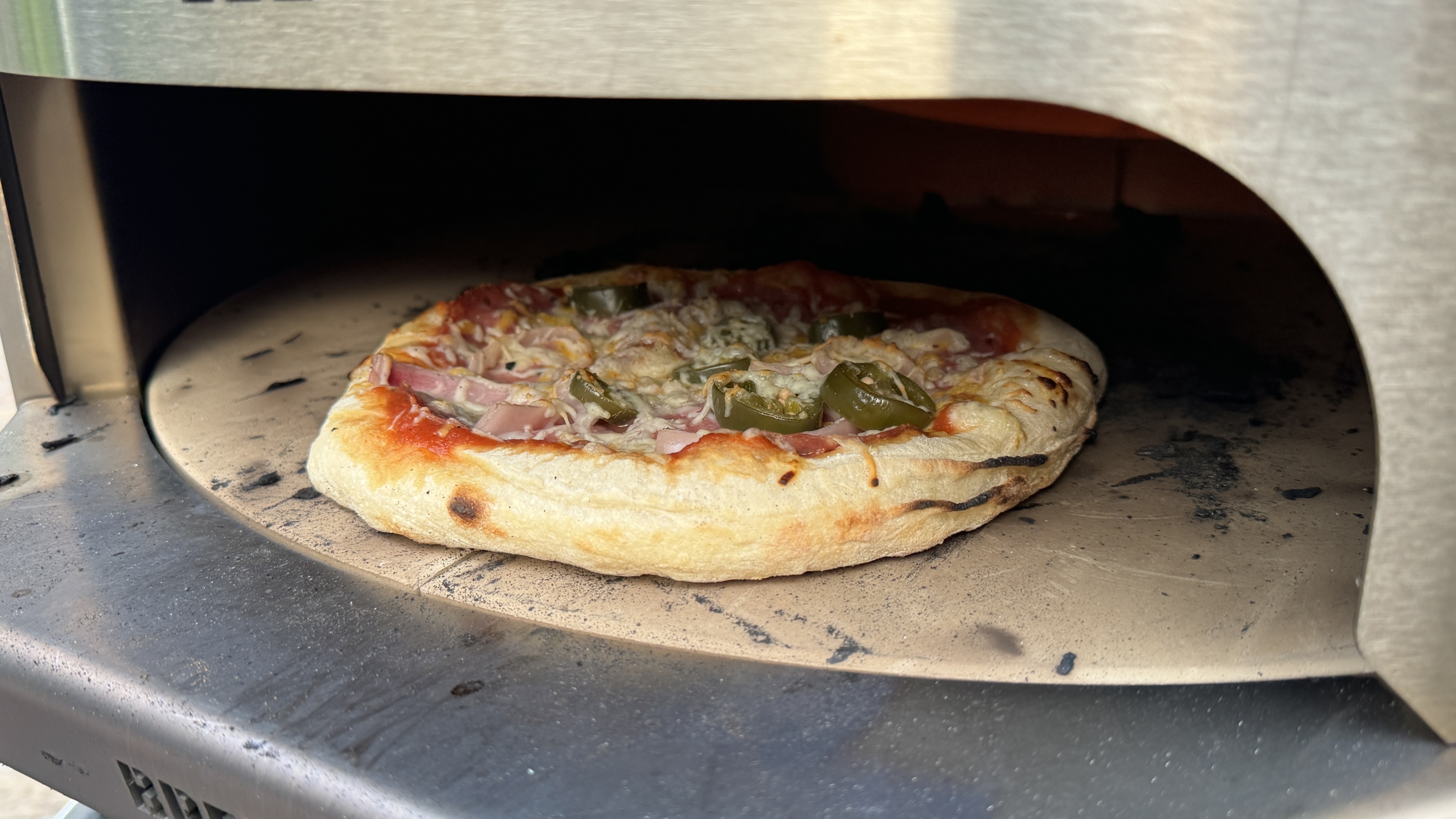 breeo live fire pizza oven cooking a pizza during testing