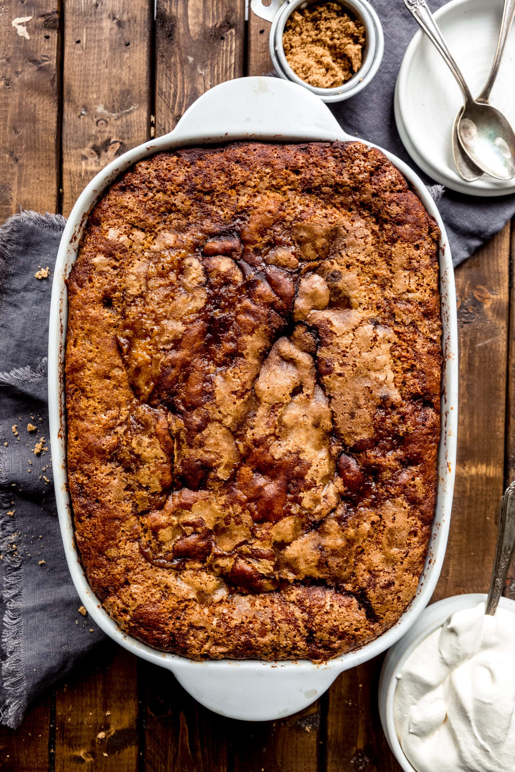 a photo of a whole baked pumpkin lava cake in a rounded rectangular white baking dish.