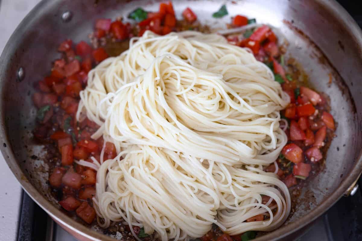 Cooked noodles added to the pan with the tomato mixture. 