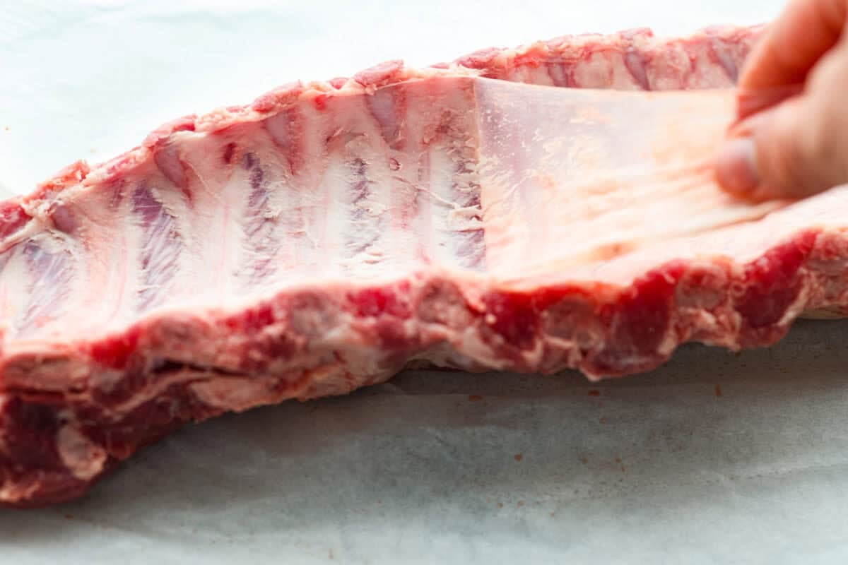 Someone peeling off the membrane from the back of the ribs.