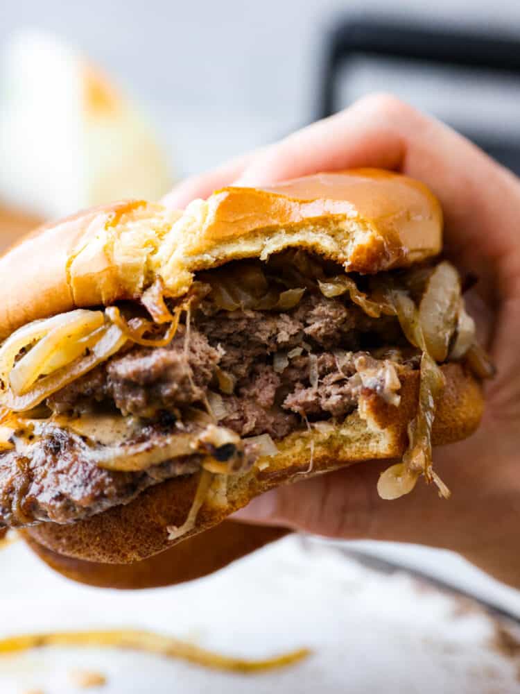 A burger with a bite taken out of it.