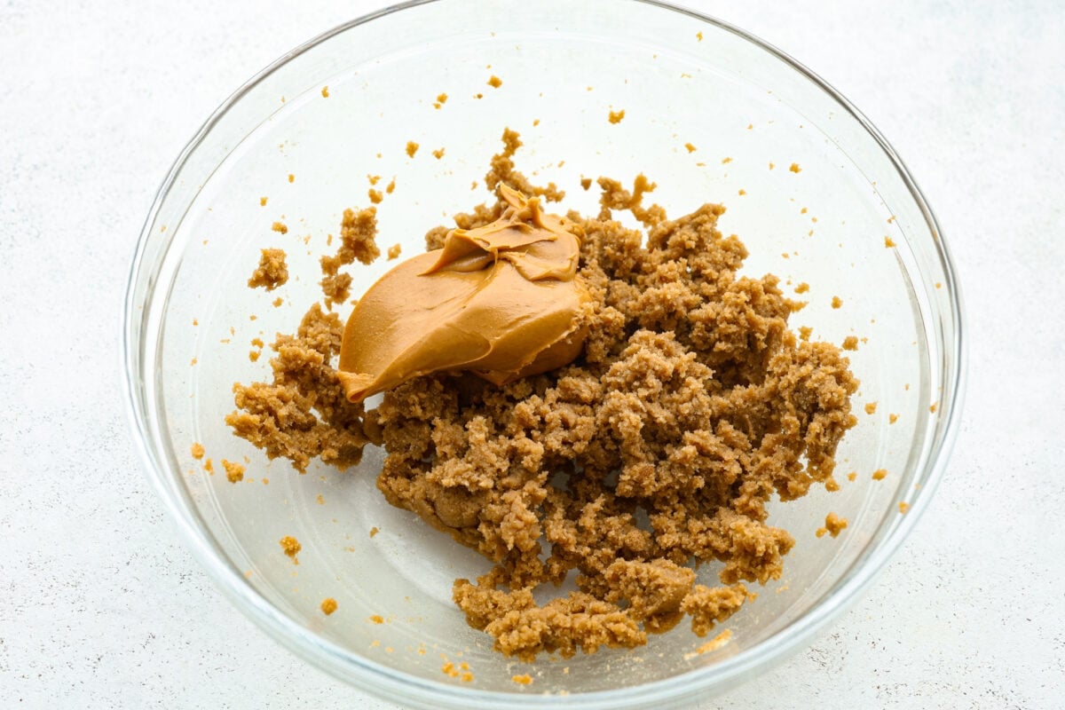 Process shot of peanut butter added to the creamed butter and sugars.