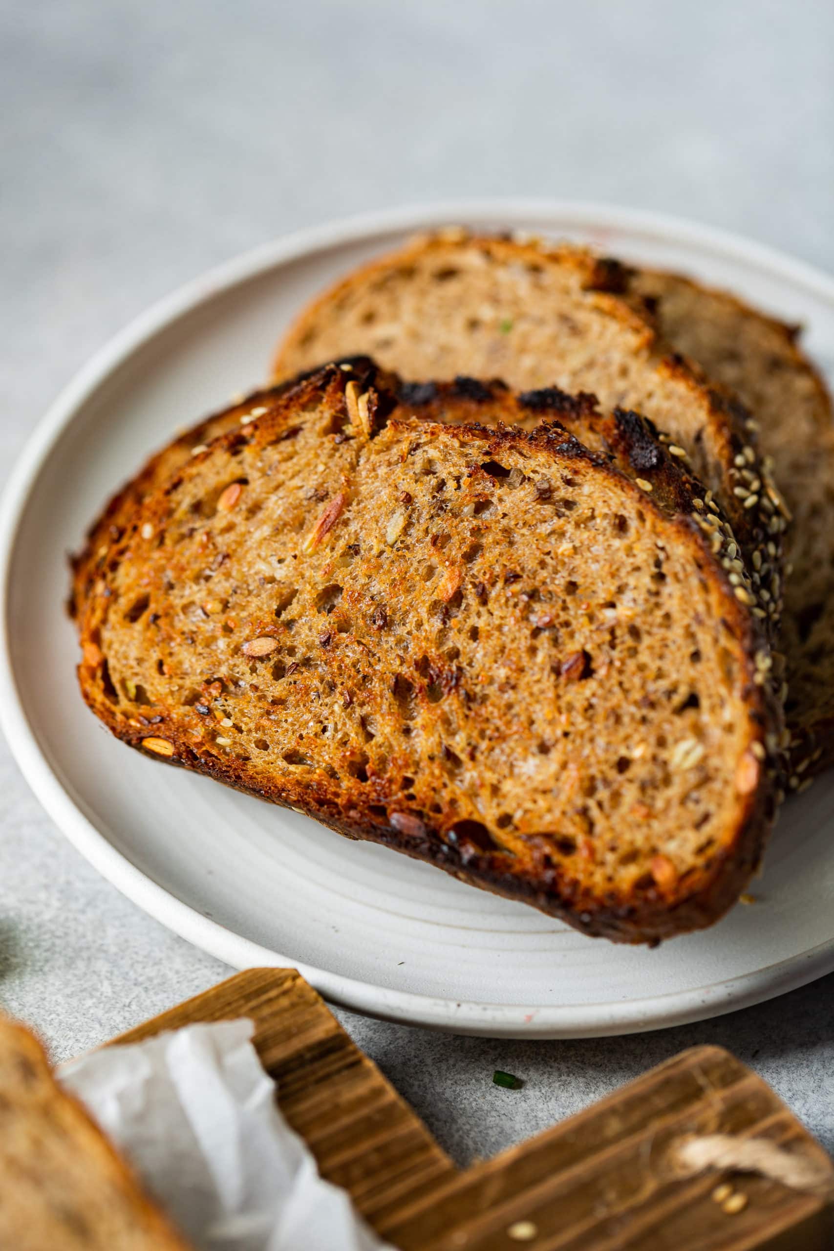 a photo of several slices of 7 grain that has been toasted sitting on a white plate.