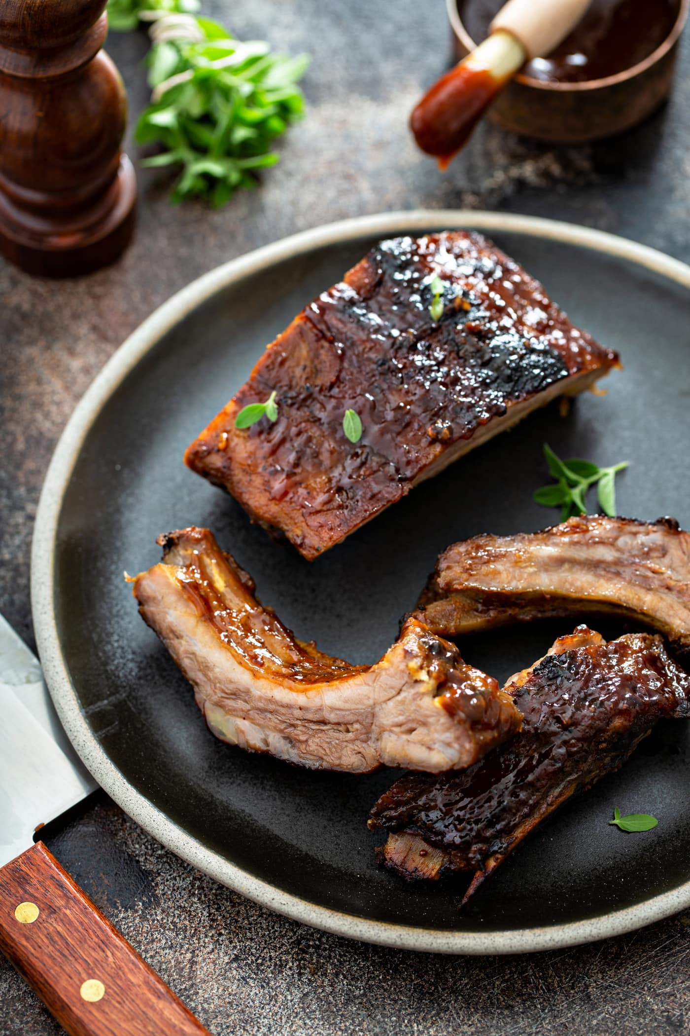 Three grilled pork ribs on a dinner plate.