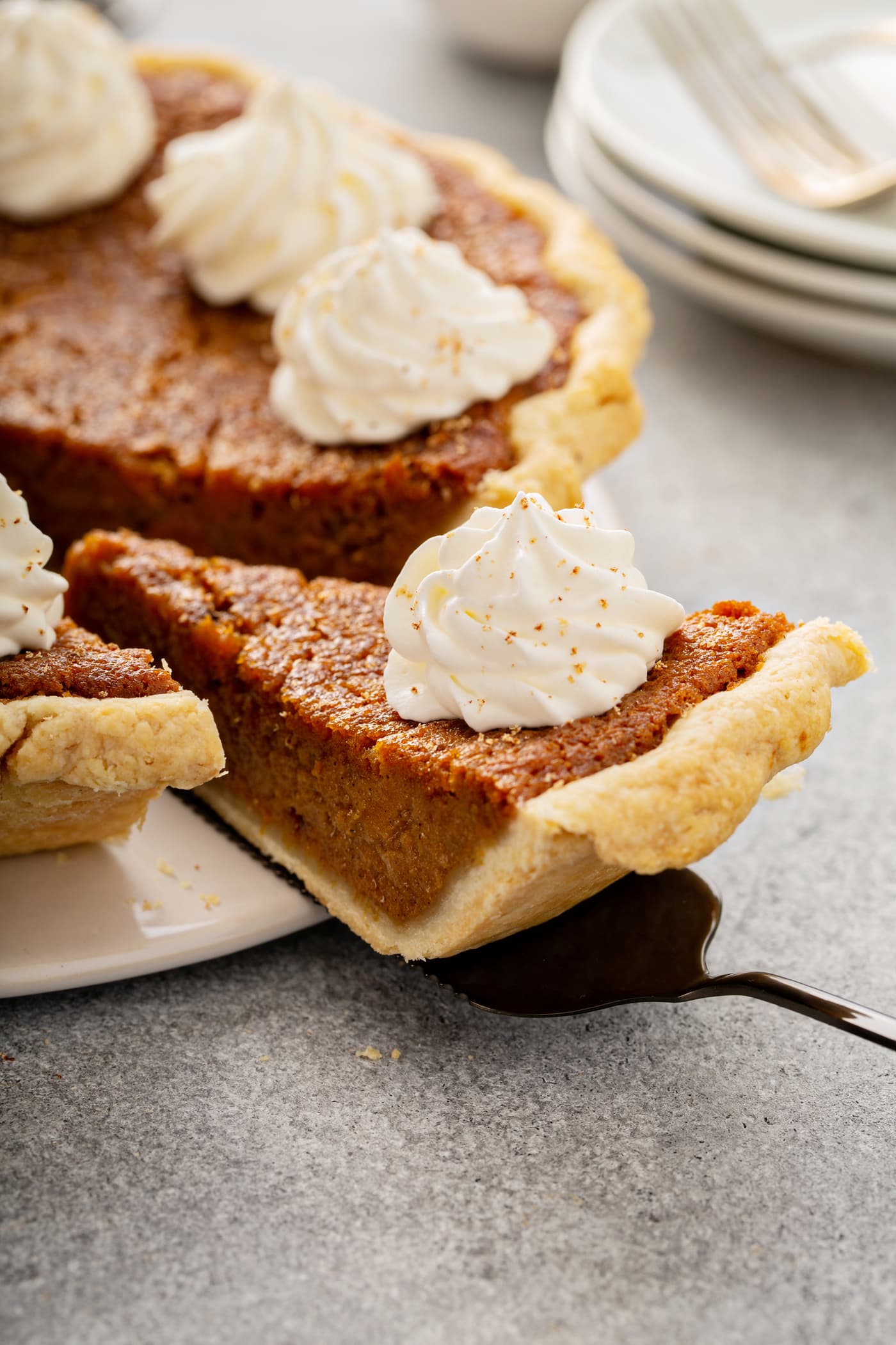 A photo of a slice of sweet potato pie being removed from a whole pie.