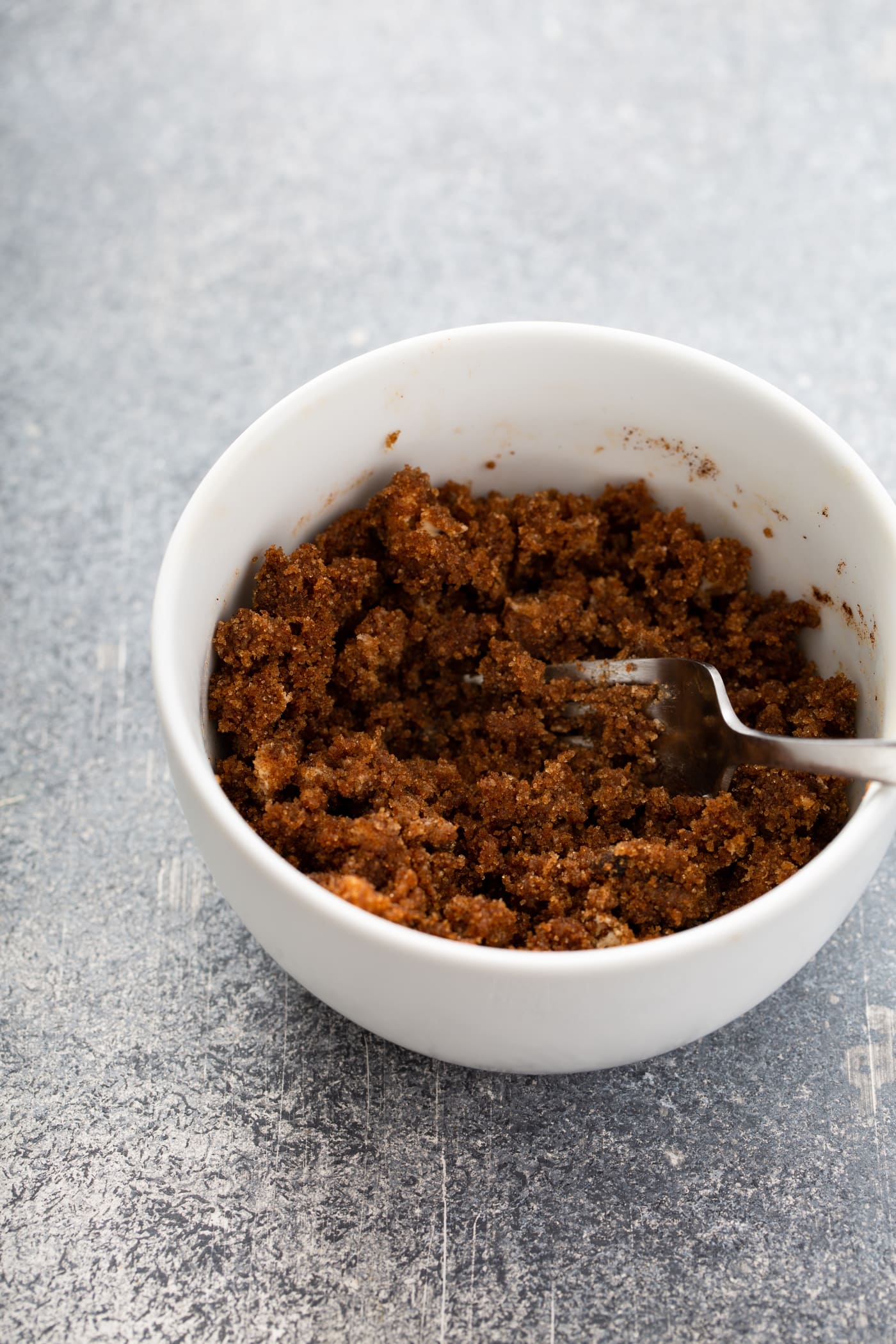 A bowl of cinnamon filling with a fork in it.