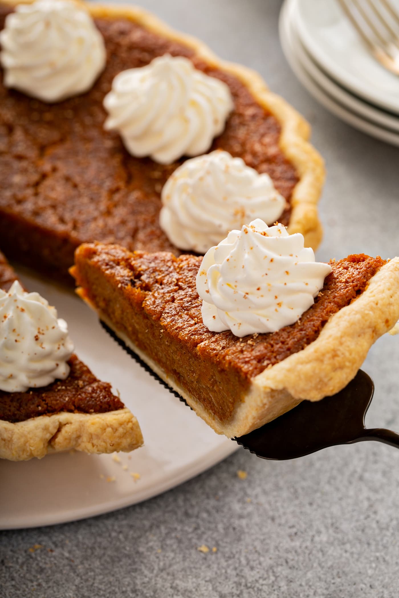 A photo of a slice of sweet potato pie being removed from a whole pie.
