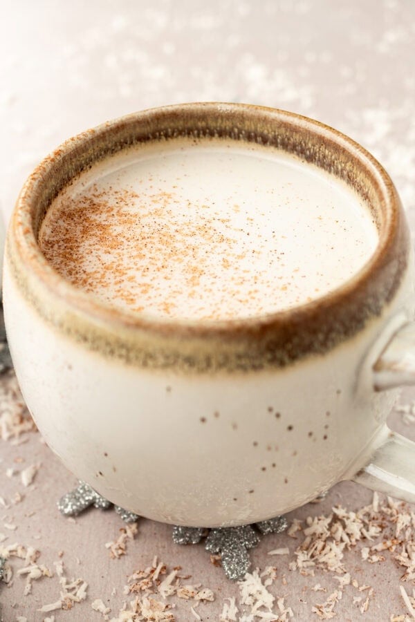 a photo of a mug full of warm vanilla milk and topped with a sprinkle of cinnamon a photo of a mug full of warm vanilla milk and topped with a sprinkle of cinnamon