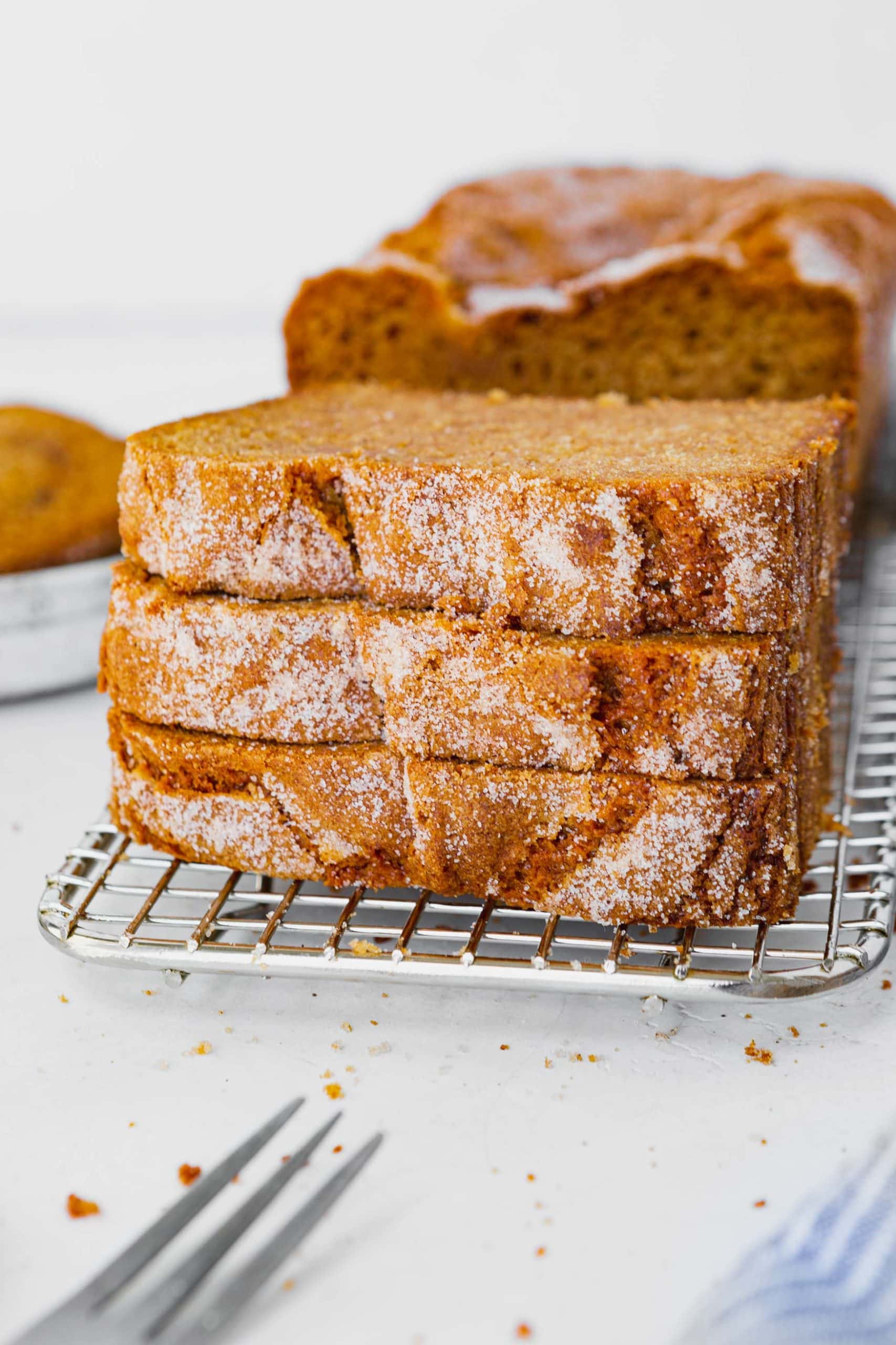 a photo of a stack of three amish friendship bread slices sitting on a wire cooling rack. a photo of a stack of three amish friendship bread slices sitting on a wire cooling rack.