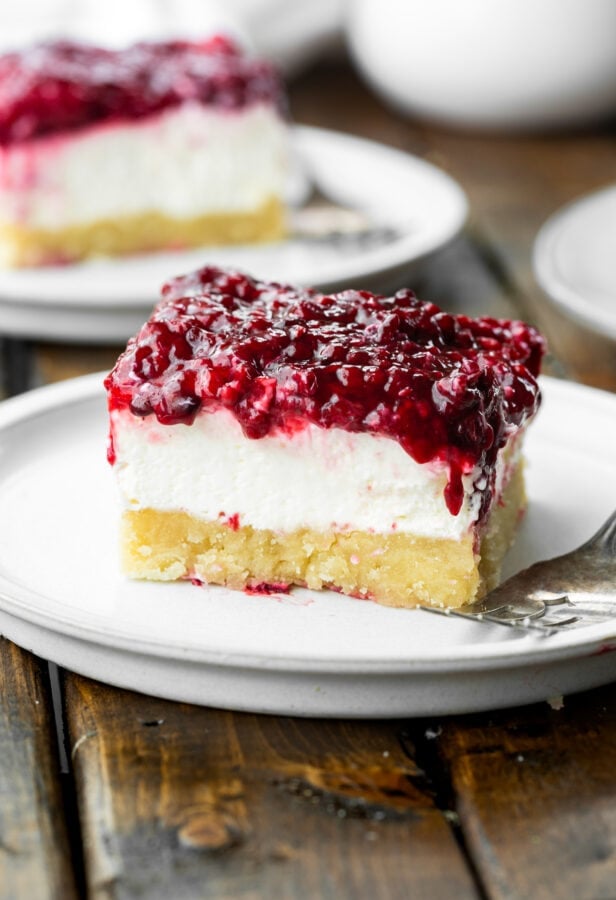 a photo of a cheesecake bar with a thick crust, creamy cheesecake layer and a mixed berry topping. a photo of a cheesecake bar with a thick crust, creamy cheesecake layer and a mixed berry topping.