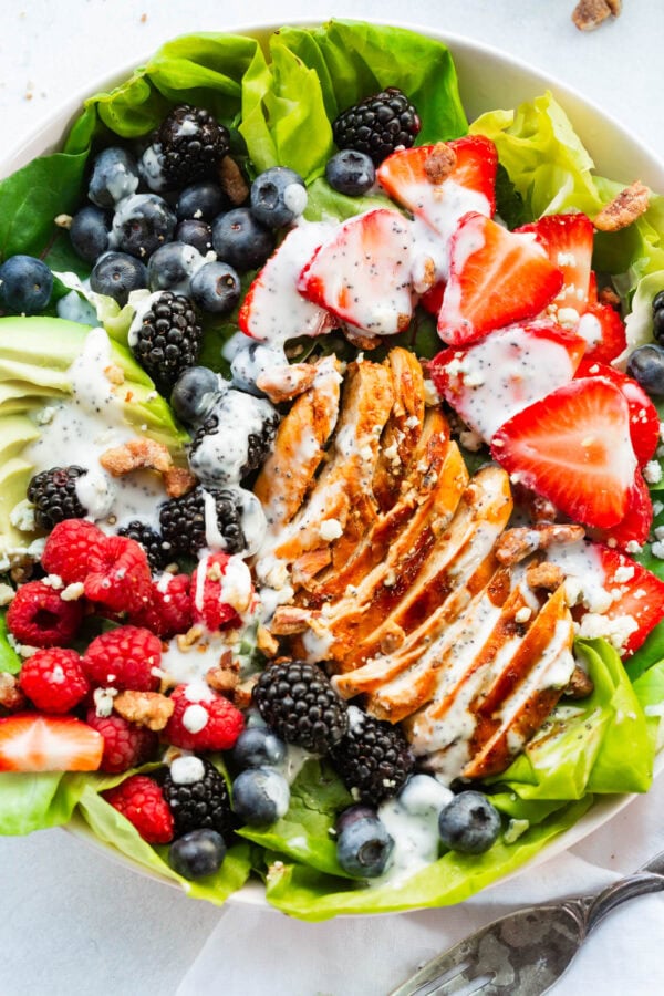 a photo of a berry avocado salad with chicken and candied pecan topped with a creamy poppyseed dressing a photo of a berry avocado salad with chicken and candied pecan topped with a creamy poppyseed dressing