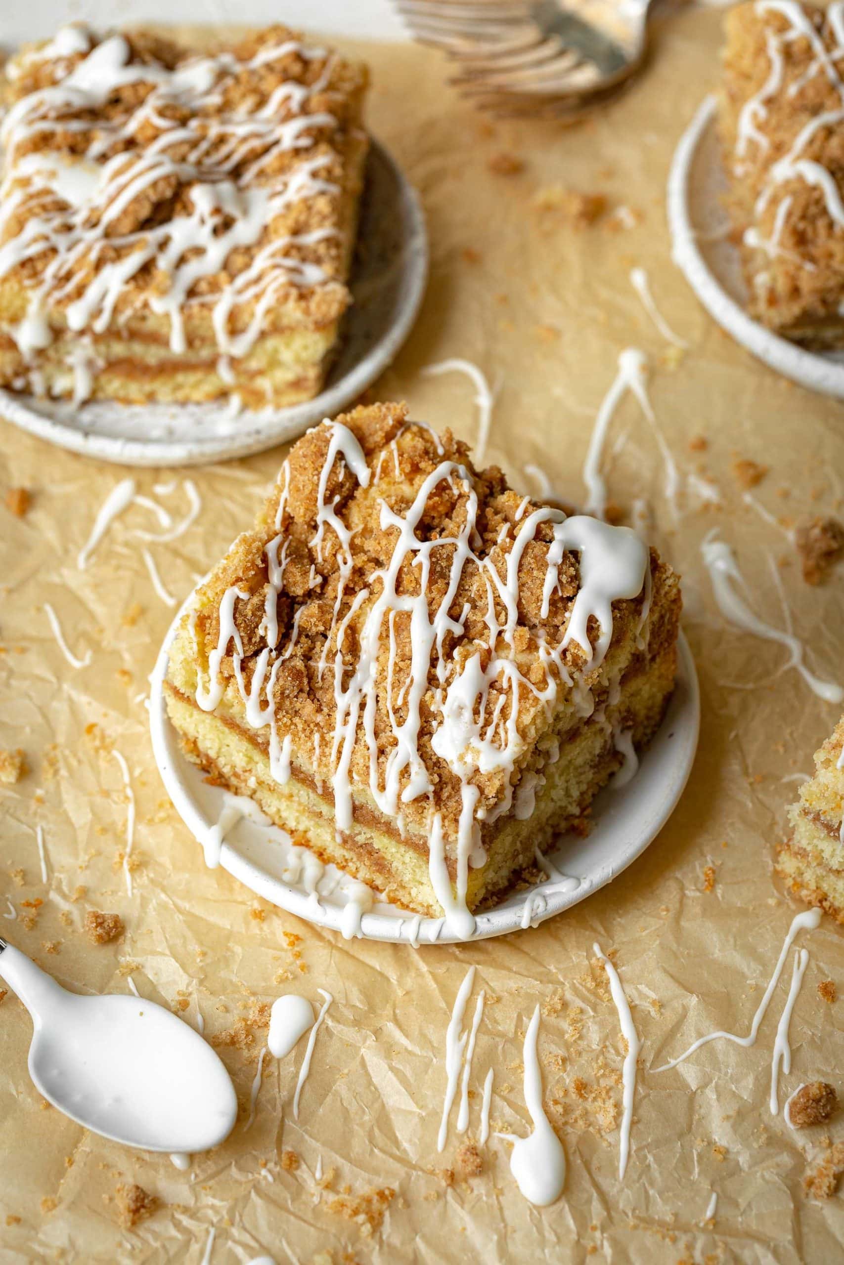 a photo of a piece of coffee cake sitting on a small saucer and the piece has been drizzled with icing. a photo of a piece of coffee cake sitting on a small saucer and the piece has been drizzled with icing.