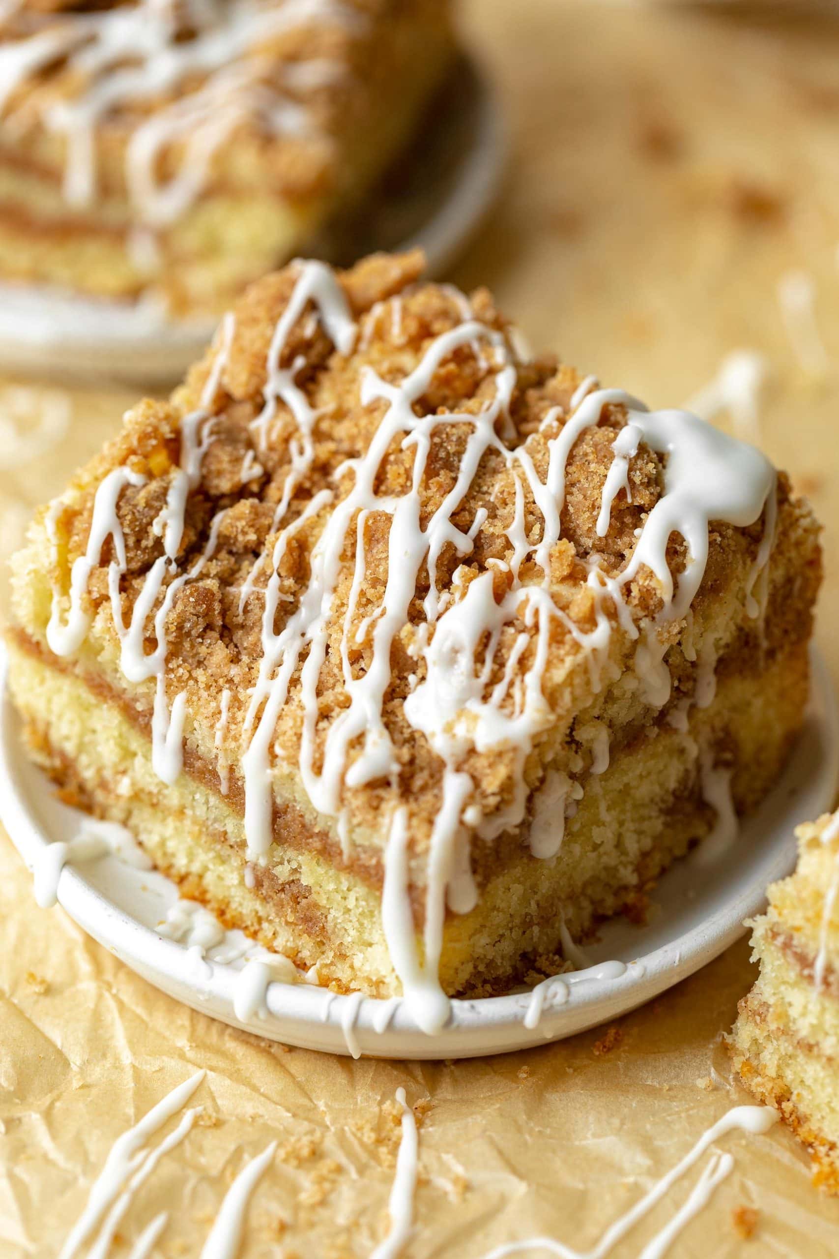 a photo of a piece of coffee cake topped with a cinnamon streusel and drizzles of icing. a photo of a piece of coffee cake topped with a cinnamon streusel and drizzles of icing.