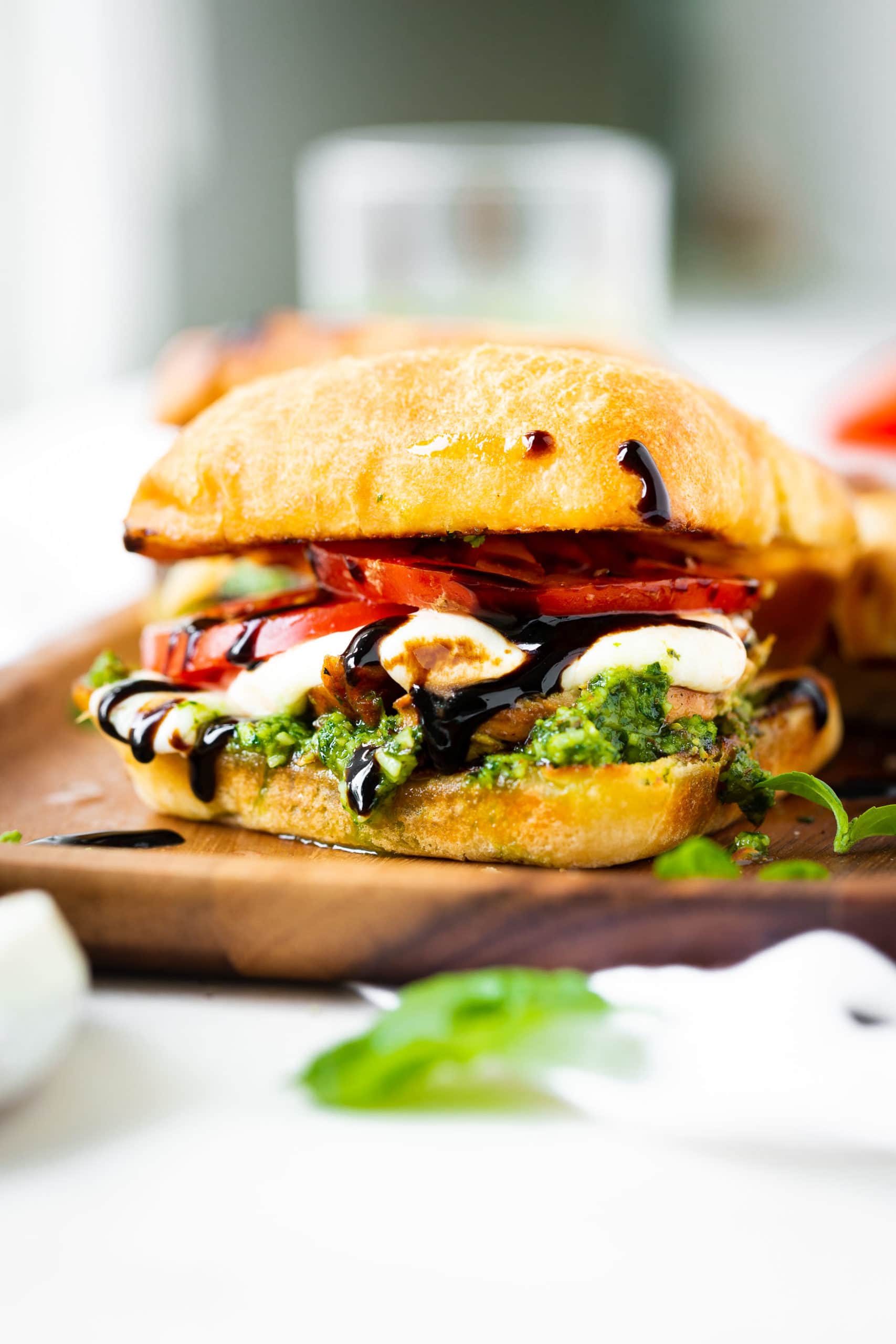 a photo of a chicken caprese sandwich on a ciabatta bun with tomato, fresh mozzarella, pesto and balsamic glaze. a photo of a chicken caprese sandwich on a ciabatta bun with tomato, fresh mozzarella, pesto and balsamic glaze.
