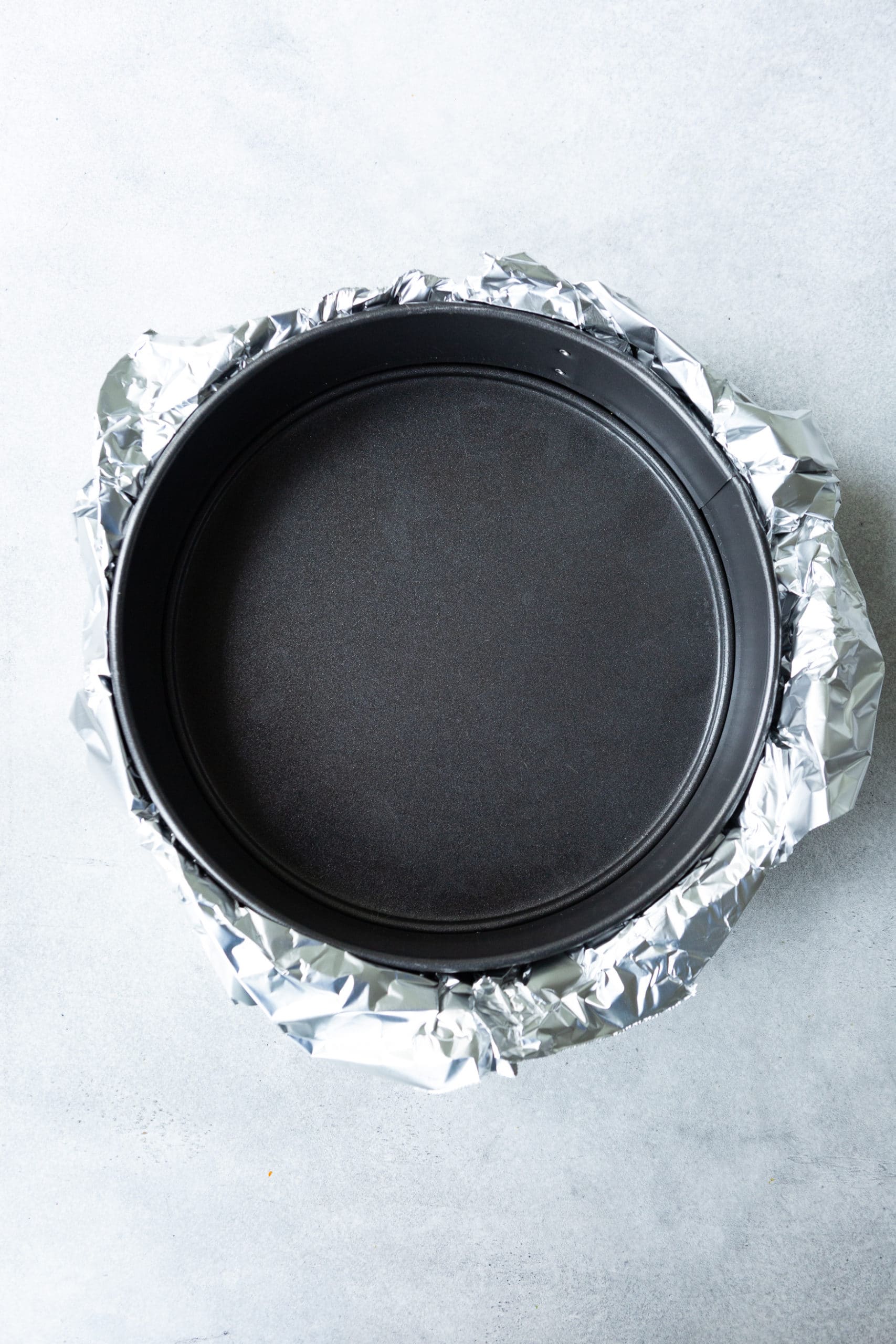 a photo of a 9 springform pan with the bottom wrapped in Reynolds Wrap Heavy Duty Foil. a photo of a 9 springform pan with the bottom wrapped in Reynolds Wrap Heavy Duty Foil.