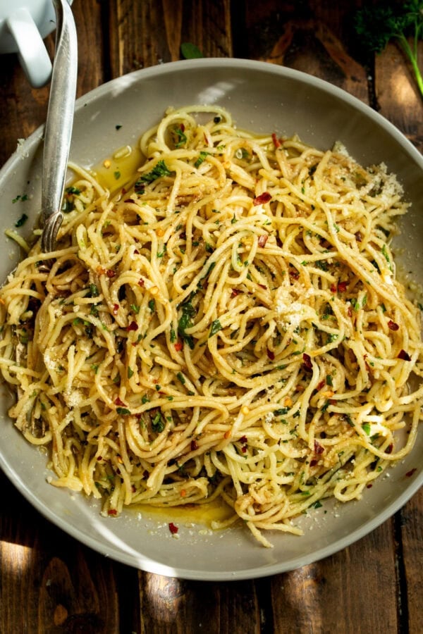 a photo of a large plate full of cooked spaghetti pasta tossed with hot oil and herbs a photo of a large plate full of cooked spaghetti pasta tossed with hot oil and herbs