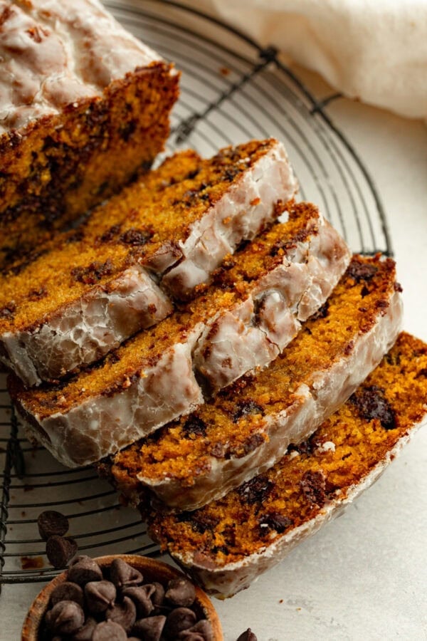 a loaf of glazed pumpkin chocolate chip bread cut into slices a loaf of glazed pumpkin chocolate chip bread cut into slices