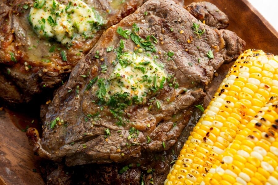a grilled ribeye steak with a pat of garlic butter on top a grilled ribeye steak with a pat of garlic butter on top