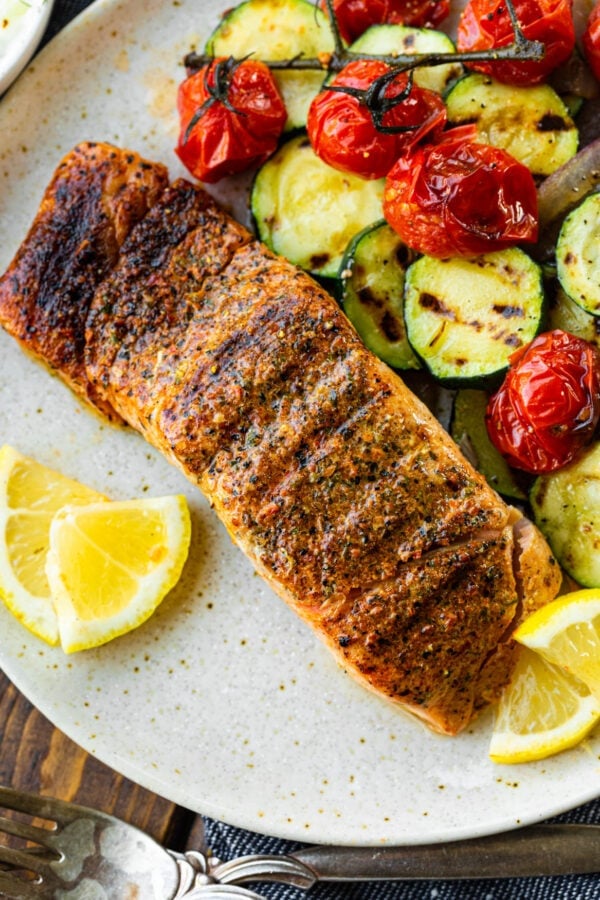 a photo of a perfectly grilled salmon fillet with lemon slices on the side and grilled zucchini and cherry tomatoes a photo of a perfectly grilled salmon fillet with lemon slices on the side and grilled zucchini and cherry tomatoes