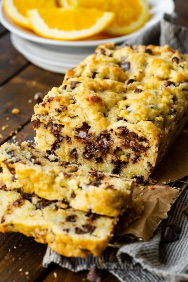 a photo of a loaf of chocolate orange scone bread with a few slices cut off loaded with chocolate chips. a photo of a loaf of chocolate orange scone bread with a few slices cut off loaded with chocolate chips.