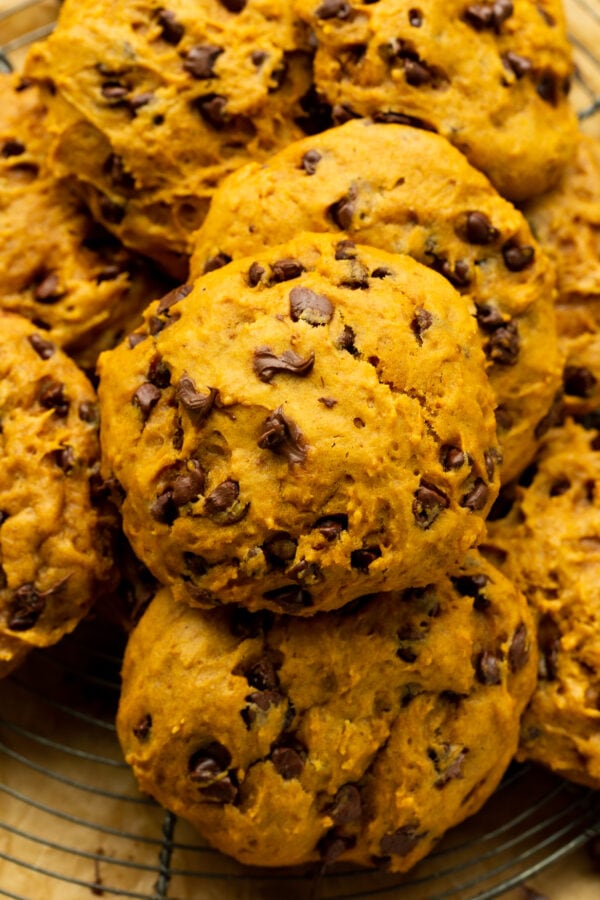 a photo of baked pumpkin chocolate chip cookies piled on top of each other a photo of baked pumpkin chocolate chip cookies piled on top of each other