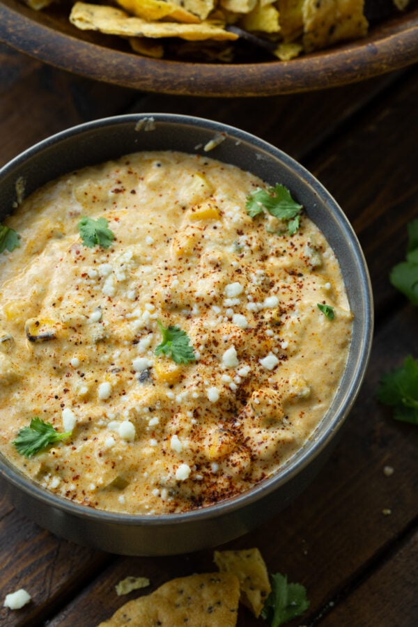 a photo of a large bowl of creamy mexican street corn dip. a photo of a large bowl of creamy mexican street corn dip.