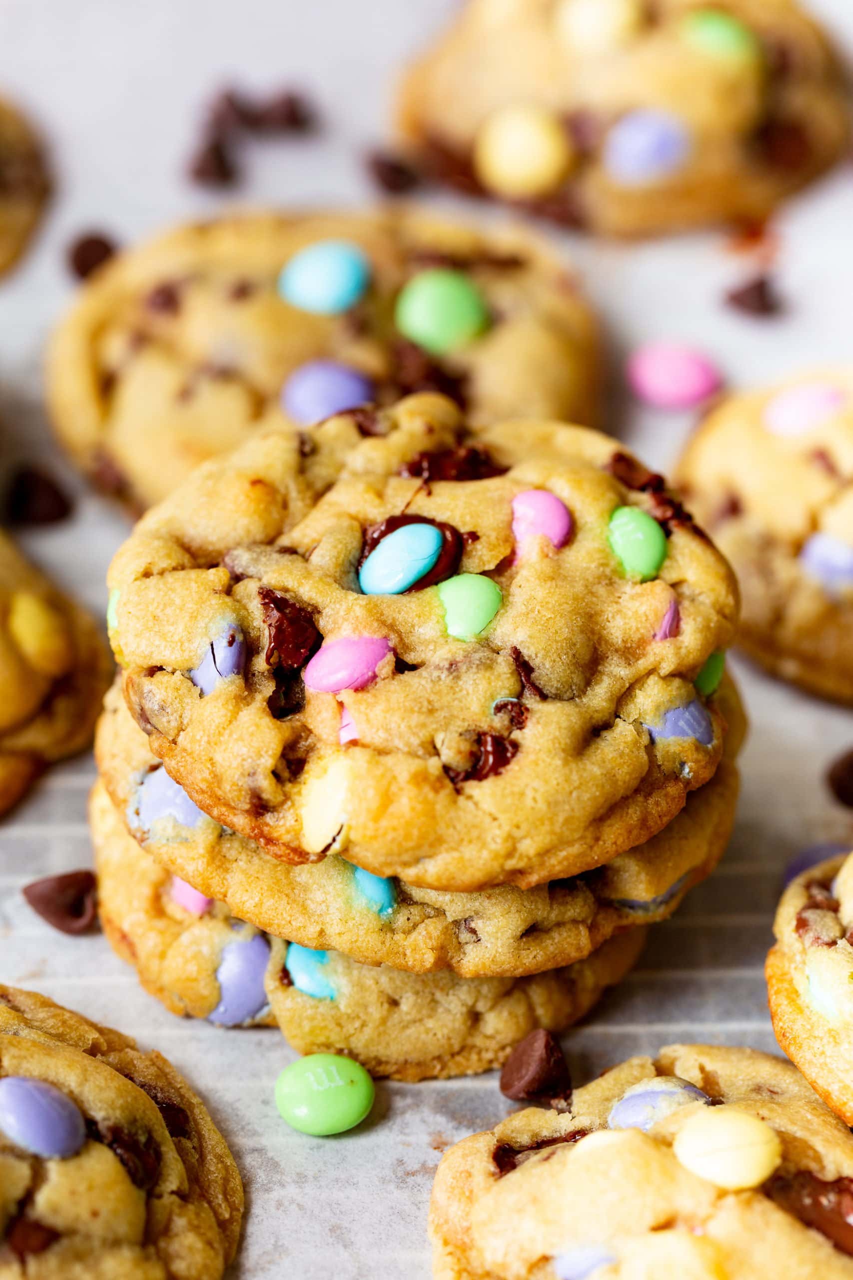 a photo of a stack of three golden thick Easter m&m chocolate chip cookies. a photo of a stack of three golden thick Easter m&m chocolate chip cookies.