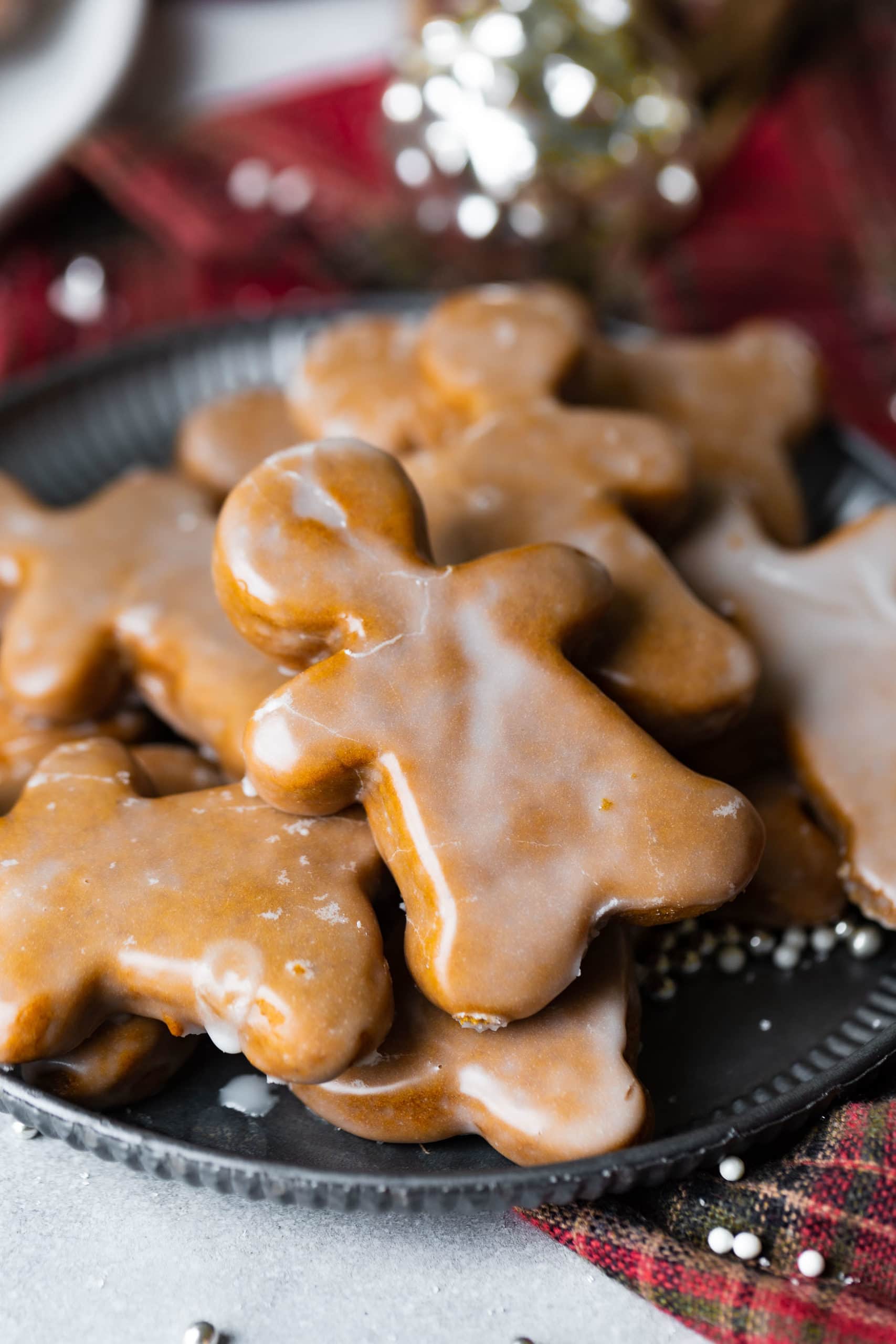 a photo of a lightly glazed gingerbread man cookie on top of a pile of other gingerbread men cookies. a photo of a lightly glazed gingerbread man cookie on top of a pile of other gingerbread men cookies.