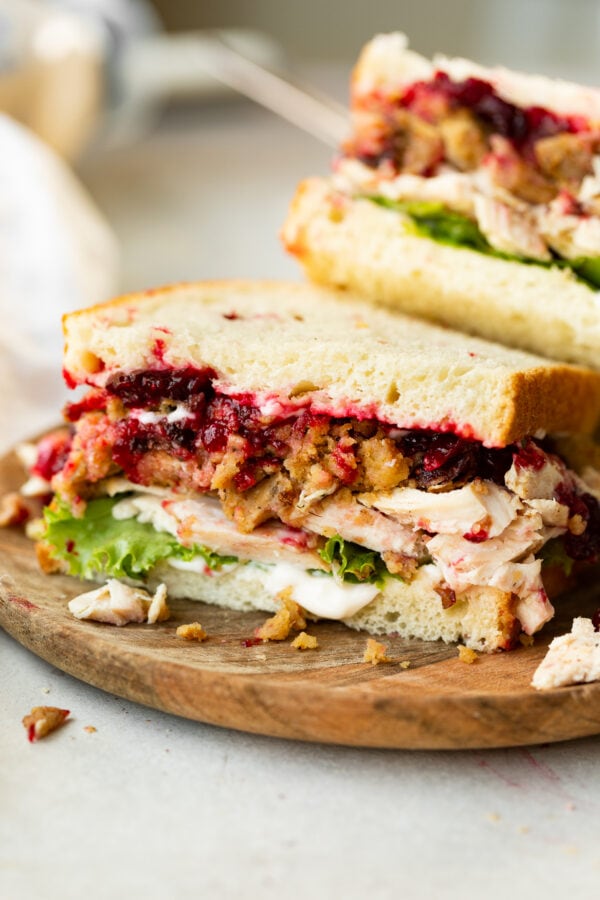 a photo of a half a turkey sandwich showing the cross section of the sandwich loaded with stuffing, cranberry sauce, turkey, lettuce, etc. a photo of a half a turkey sandwich showing the cross section of the sandwich loaded with stuffing, cranberry sauce, turkey, lettuce, etc.